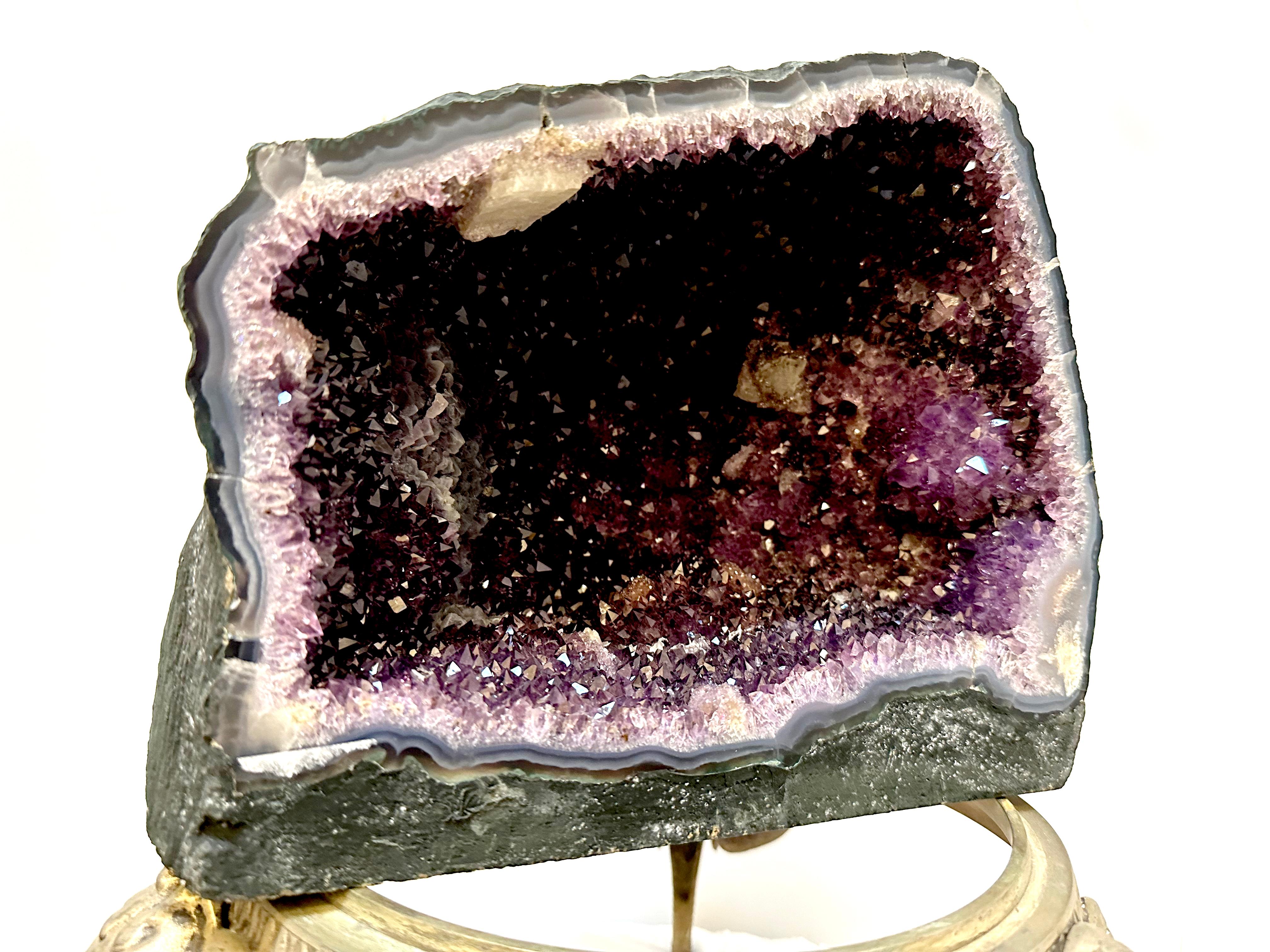 An impressive deep purple amethyst geode will lend itself to office or home decor. This is a great ornamental specimen for an office or public space display. It has calcite formations as well as areas of possible colorless quartz. 
This piece came