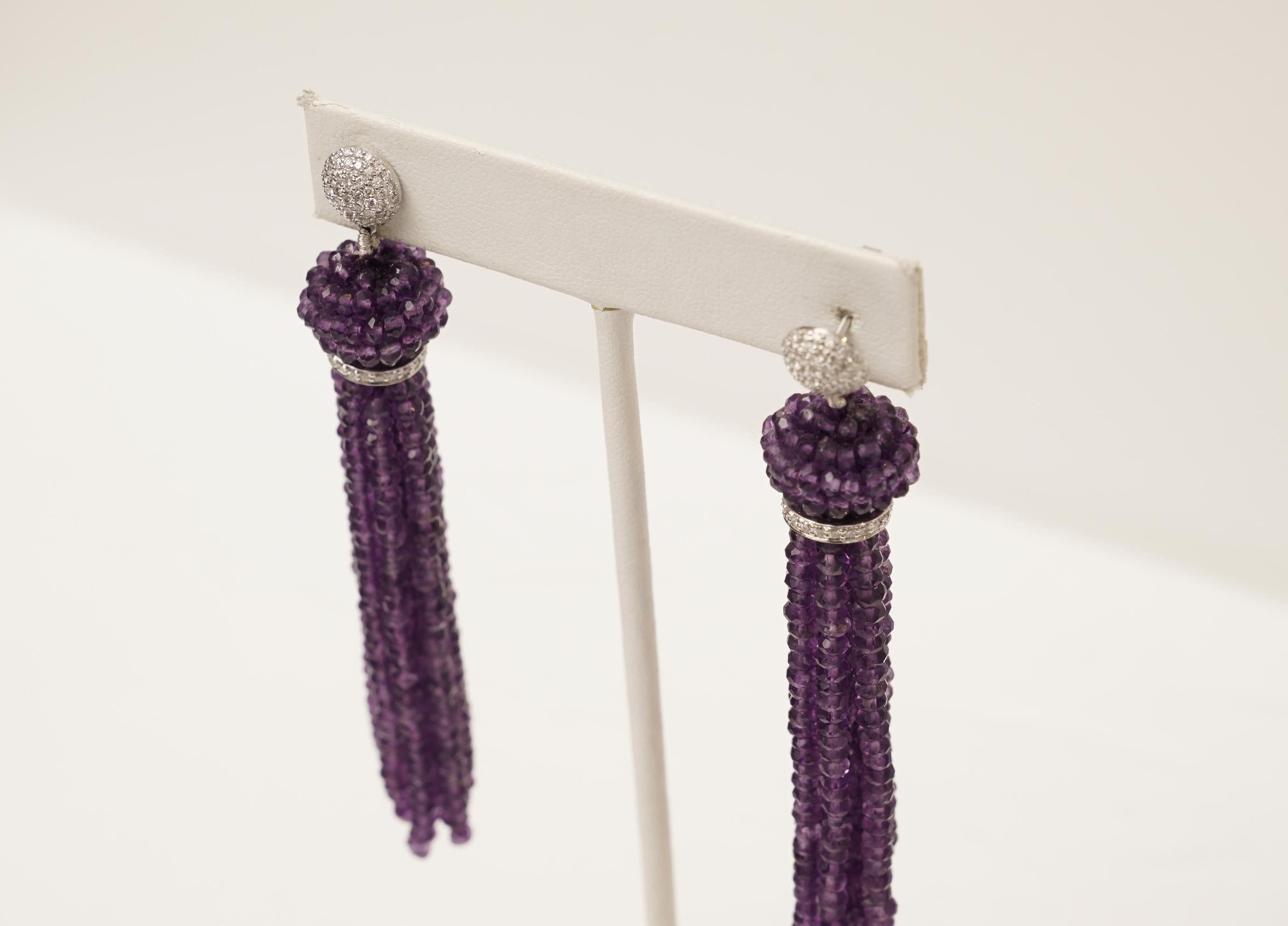A pair of faceted amethyst tassel earrings with rich color. Pave`-set diamonds along the 18K white gold rondelle and earring post, for pierced ears. Hand-woven amethyst cluster bead at the top.