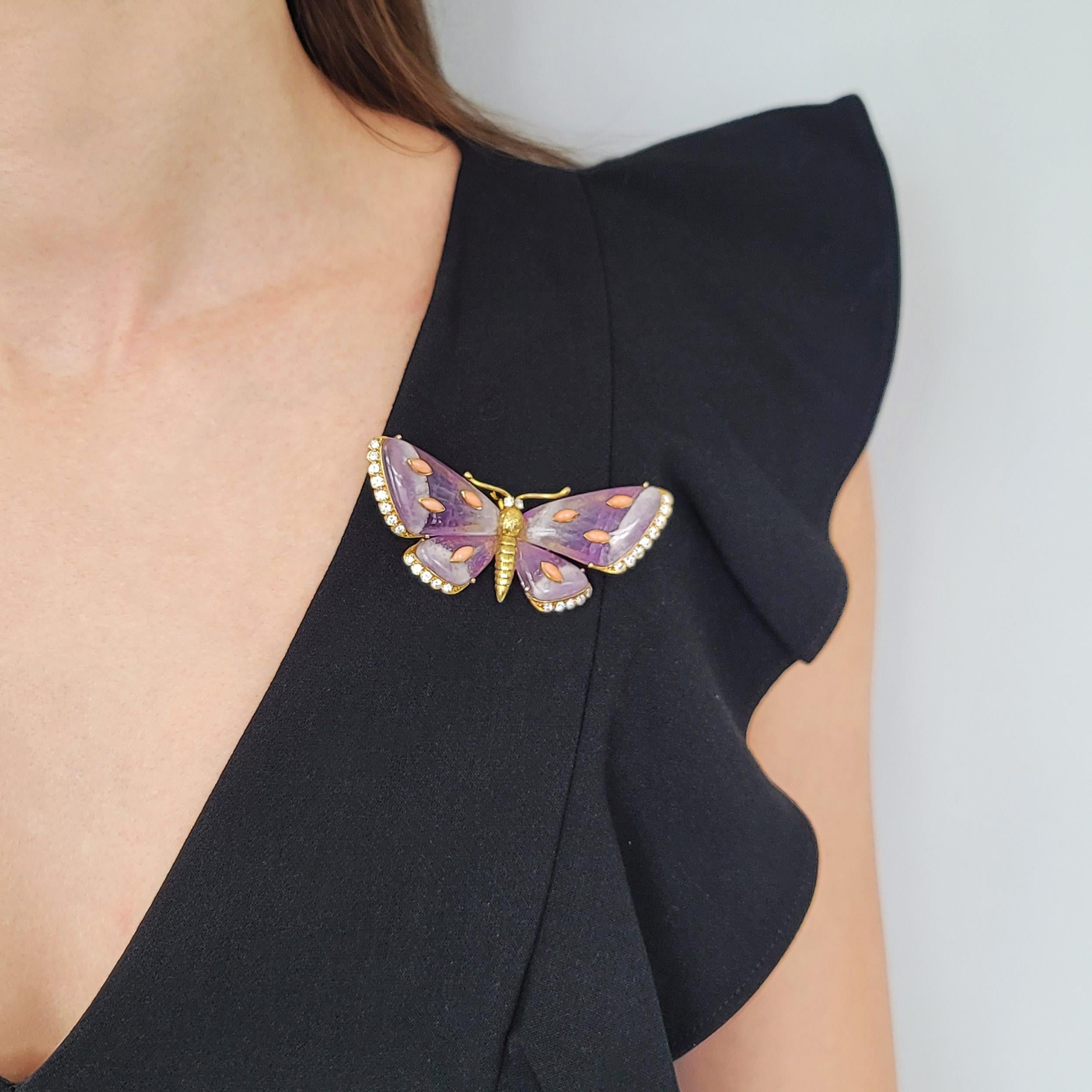 Amethyst, diamond and coral butterfly brooch in 18k yellow gold. Circa 1970's. Made in France. The butterfly features gold body, cabochon cut amethyst wings with 8 cabochon cut pink
coral spots. Edges of the wings and eyes set with round brilliant