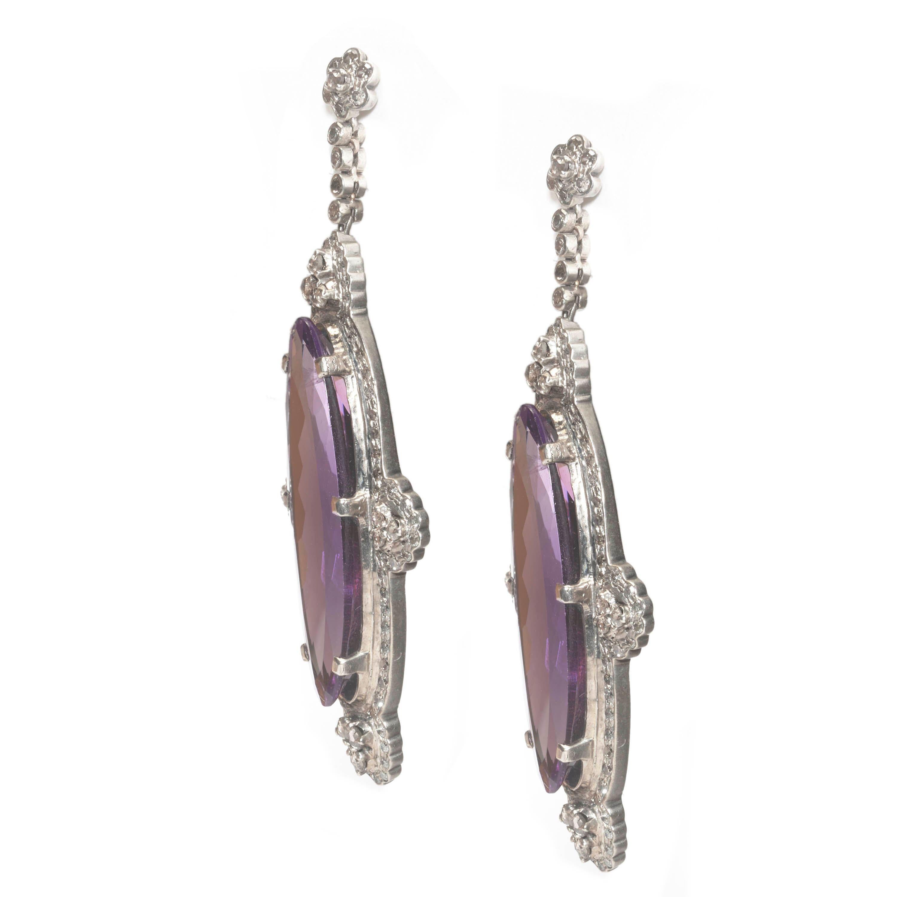 A pair of modern amethyst and diamond earrings, set with long oval faceted amethysts, weighing approximately 40.00ct, surrounded by eight-cut diamonds, with rose-cut diamond set trefoil clusters at each quarter, with rose-cut diamond set cluster