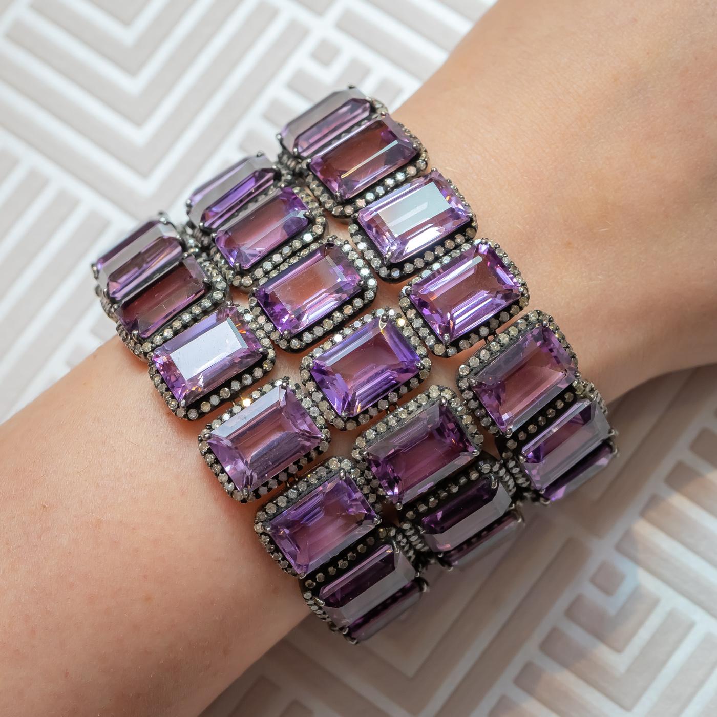 Amethyst bracelet, mounted in blackened  gold, set with emerald-cut amethysts weighing an estimated total of 279.94ct. each surrounded by a cluster of eight-cut diamonds, the clasp is pavé set with diamonds.