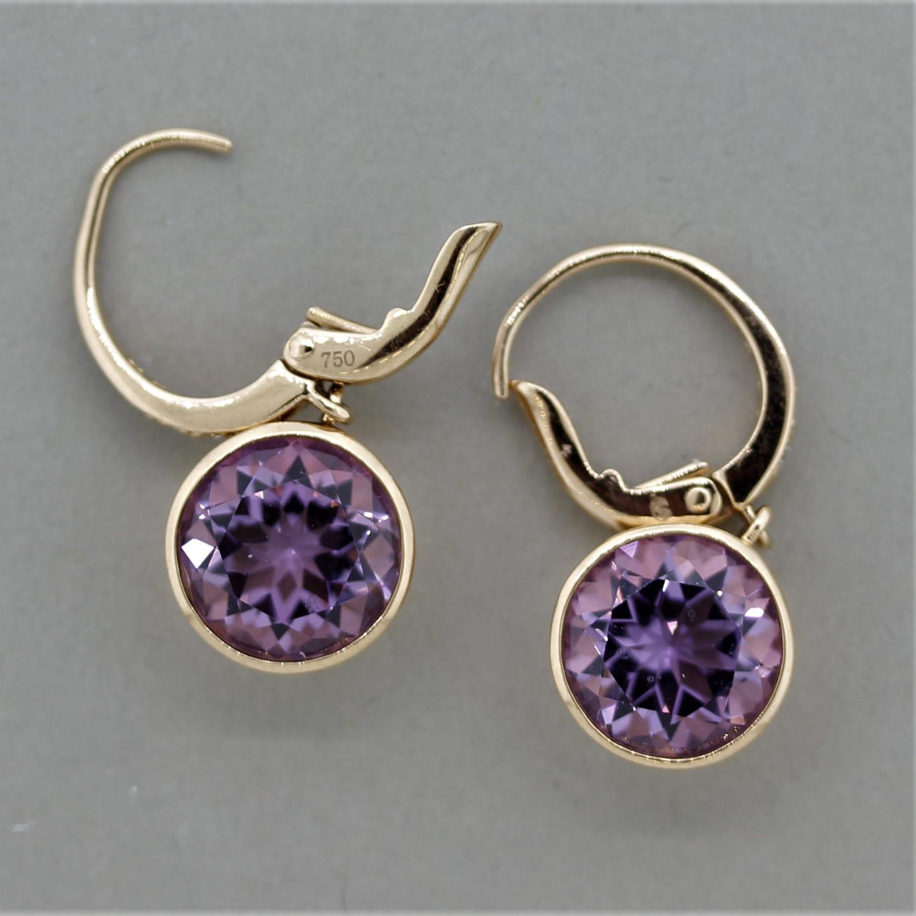 A simple yet stylish pair of modern amethyst earrings! The two amethysts have a bright purple color with a hint of pink and weigh a total of 5.30 carats. They are accented by 0.10 carats of round brilliant cut diamonds set above them. Made in 18k