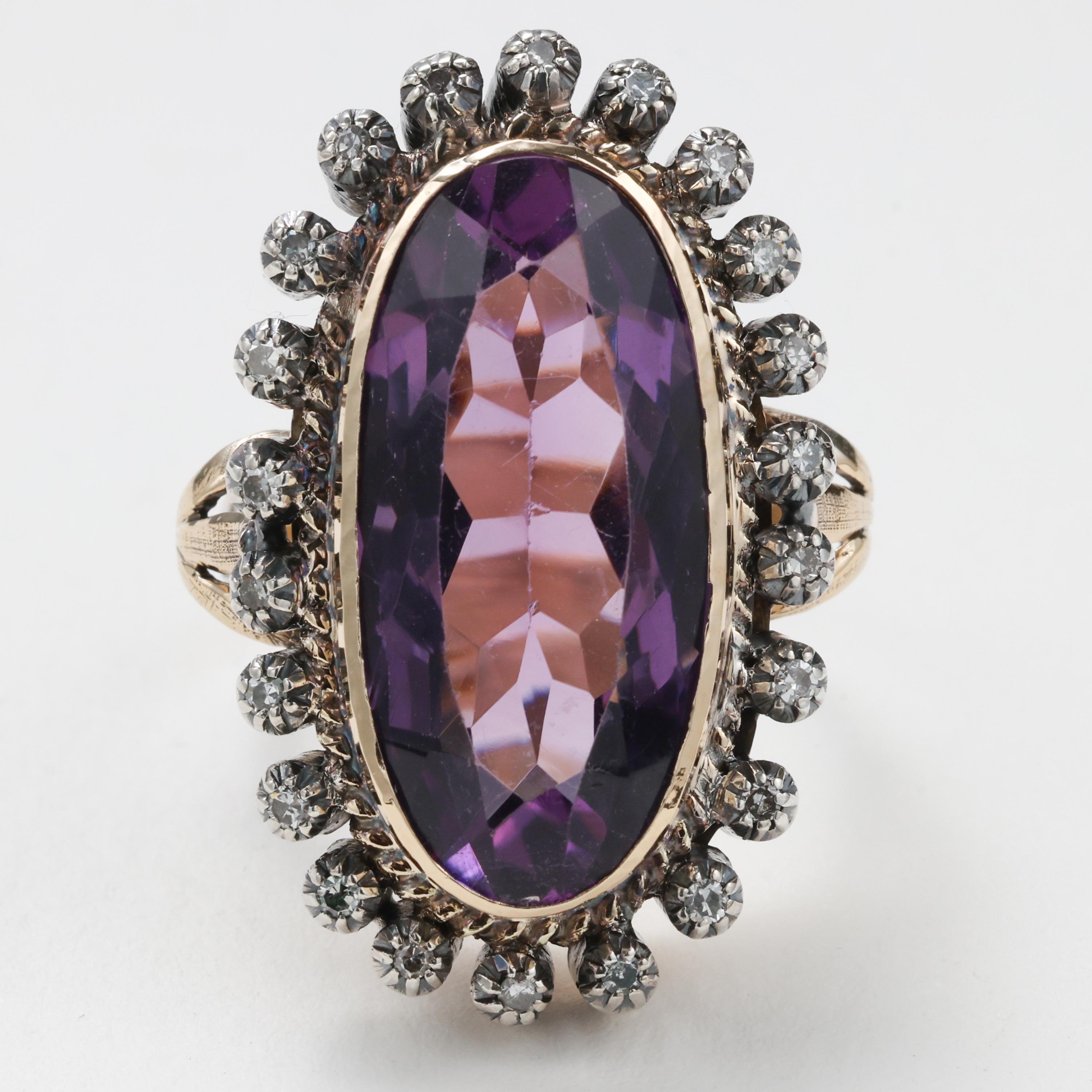 This circa 1890s ring features an impressive oblong oval-shaped 11 carat amethyst with excellent purple and rose coloring. The 23.63mm x 11.33mm is surrounded by a halo of 22 tiny European-cut diamonds, each set into its own silver collet. Together