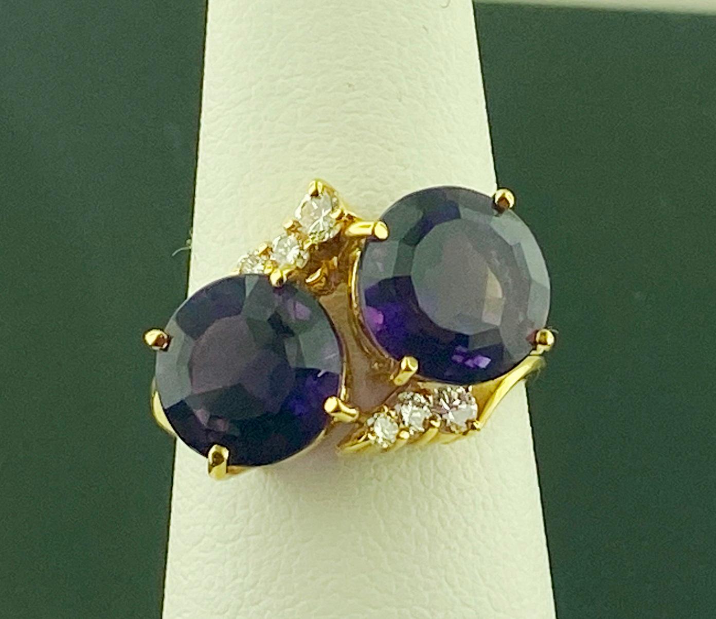 Set in 14 karat yellow gold, weighing 4.85 grams, are two Round Brilliant cut Amethysts weighing approximately 5.01 carats in total.  plus 6 Round Brilliant cut diamonds weighing approximately 0.20 carats, Color: G-H, Clarity: VS.  Ring size is 6.