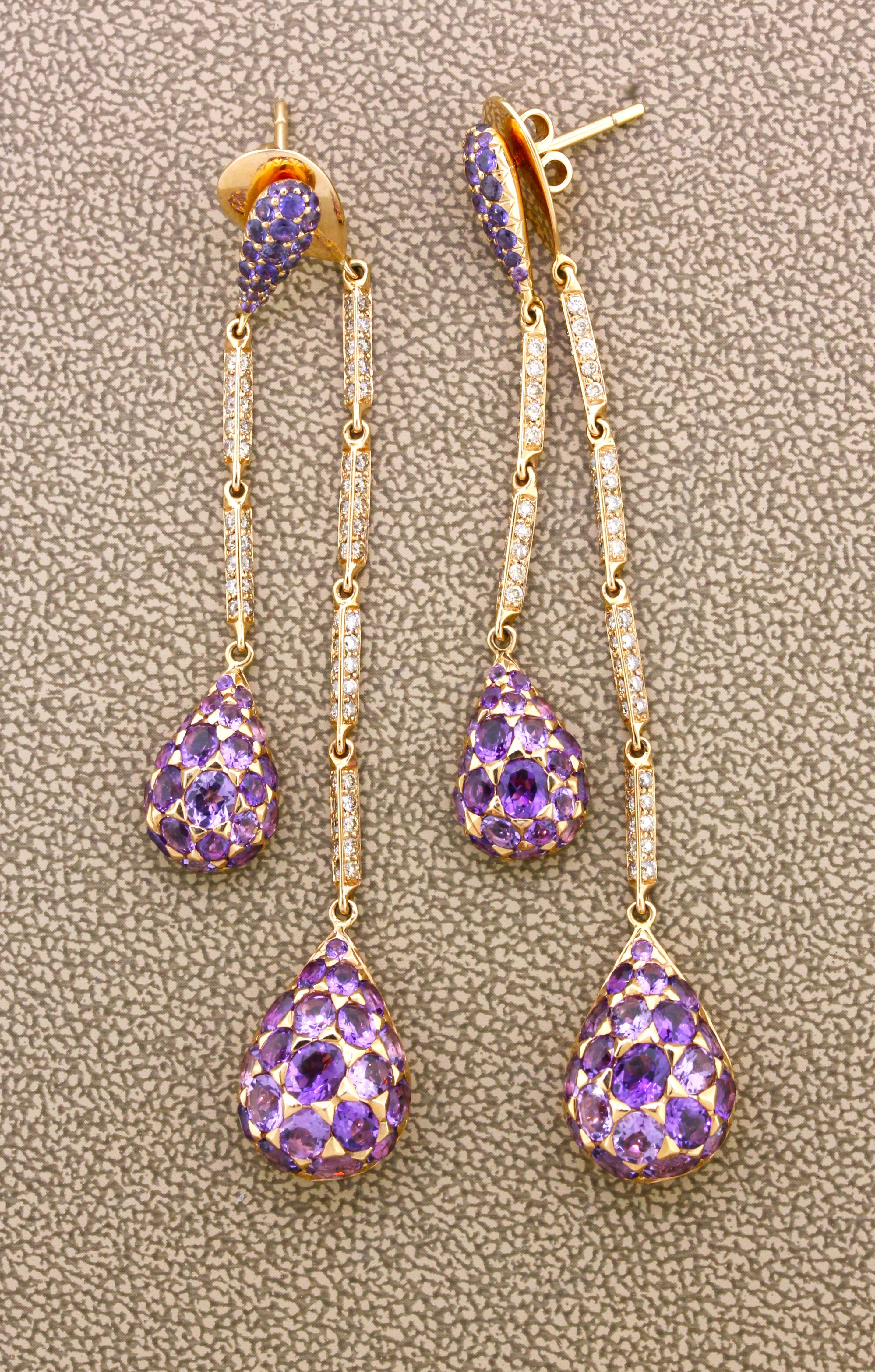 A fun and stylish pair of earrings featuring 6.40 carats of oval shape bright purple amethyst, 1.10 carats of round brilliant-cut diamonds, and 0.90 carats of vivid purple sapphire set on the top posts of the earrings. There are multiple bails and
