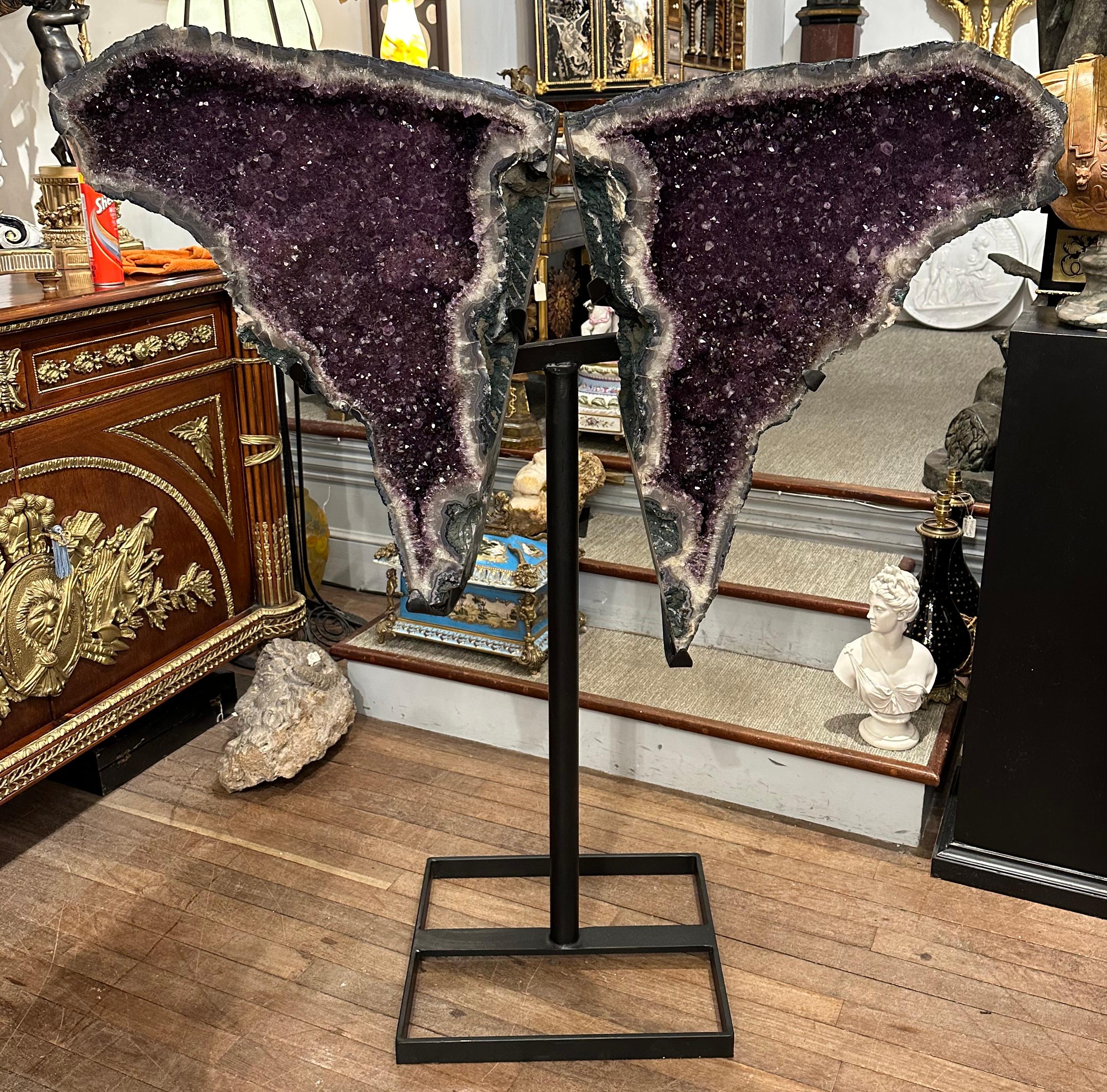 A large, rare and stunning natural pair of amethyst elephant ears on a black metal stand. This is a spectacular natural specimen, deep purple in colour. It catches the light beautifully and would be sure to be a focal point in any room. Originally