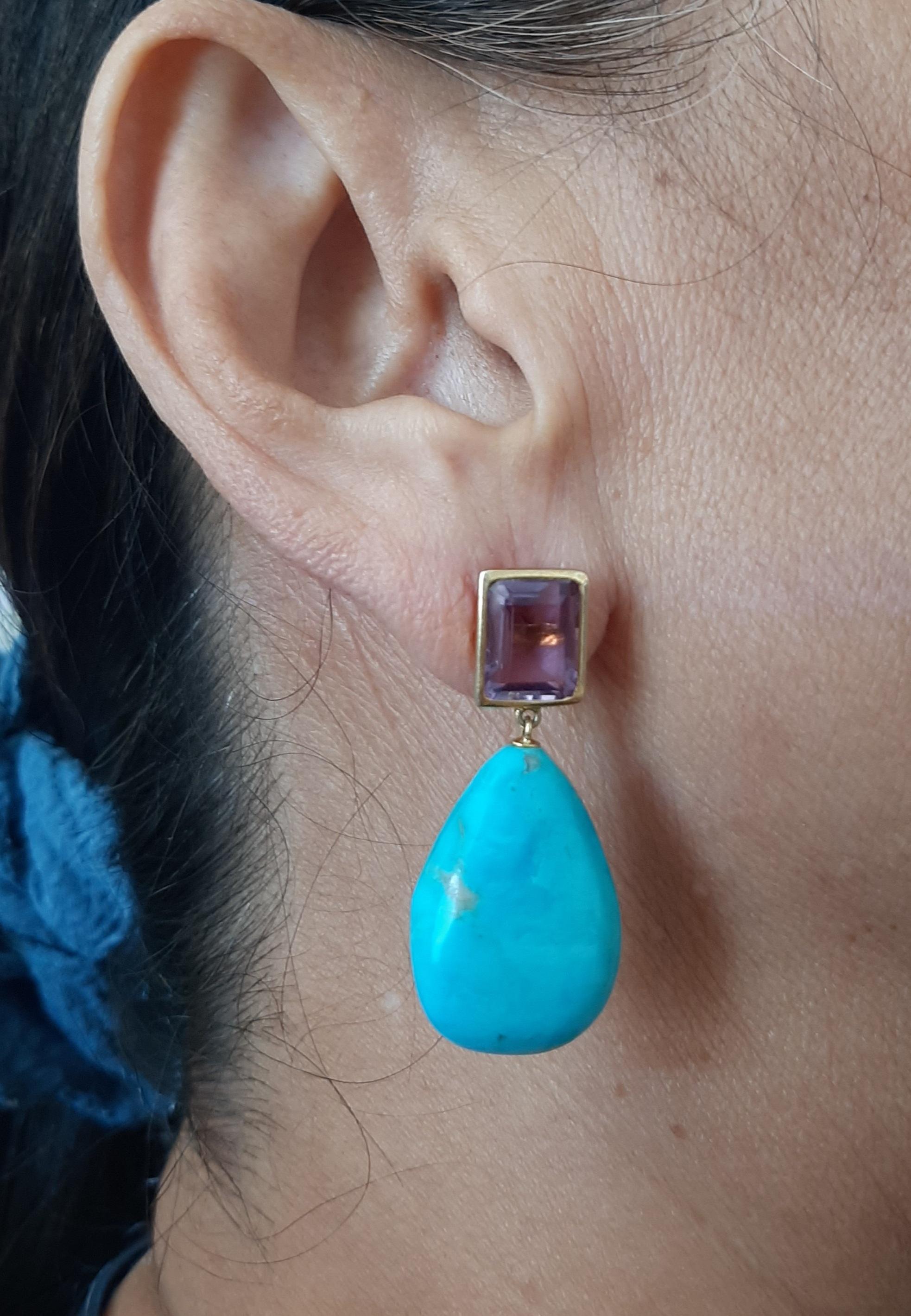 Simple y chic  pendientes con un par de  Amatista de forma octogonal tamaño 8x 10 mm engastada en bisel de oro amarillo macizo de 14 kt  en la parte superior y 2 gotas lisas de Turquesa Genuina de 17x24 mm en la parte inferior.

En 1978, nuestro