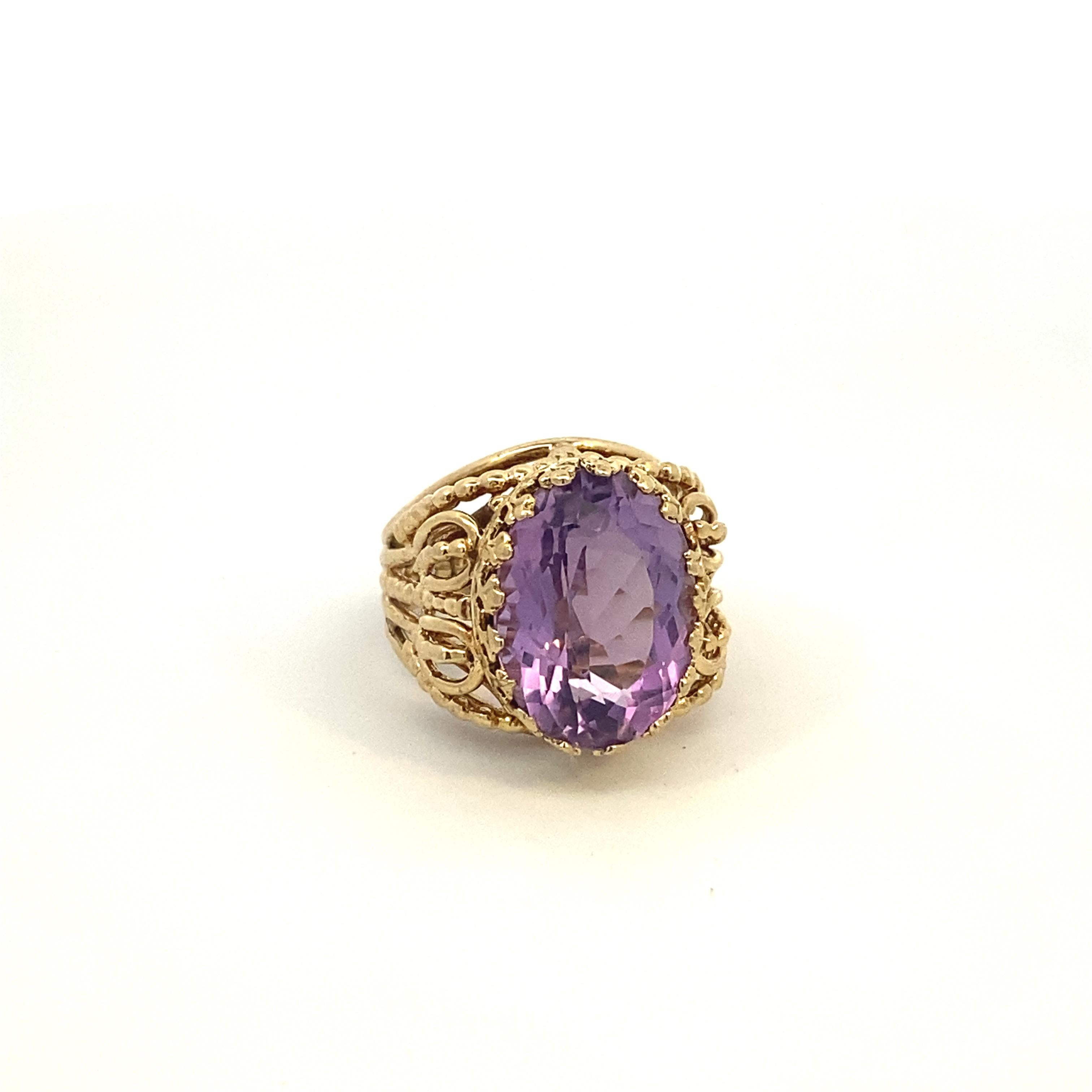Introducing our Vintage Amethyst Filigree Yellow Gold Ring, Size 7 US. This finely detailed piece features 14k yellow gold band adorned with intricate filigree detailing, showcasing its craftsmanship.

At the heart of this captivating ring lies a