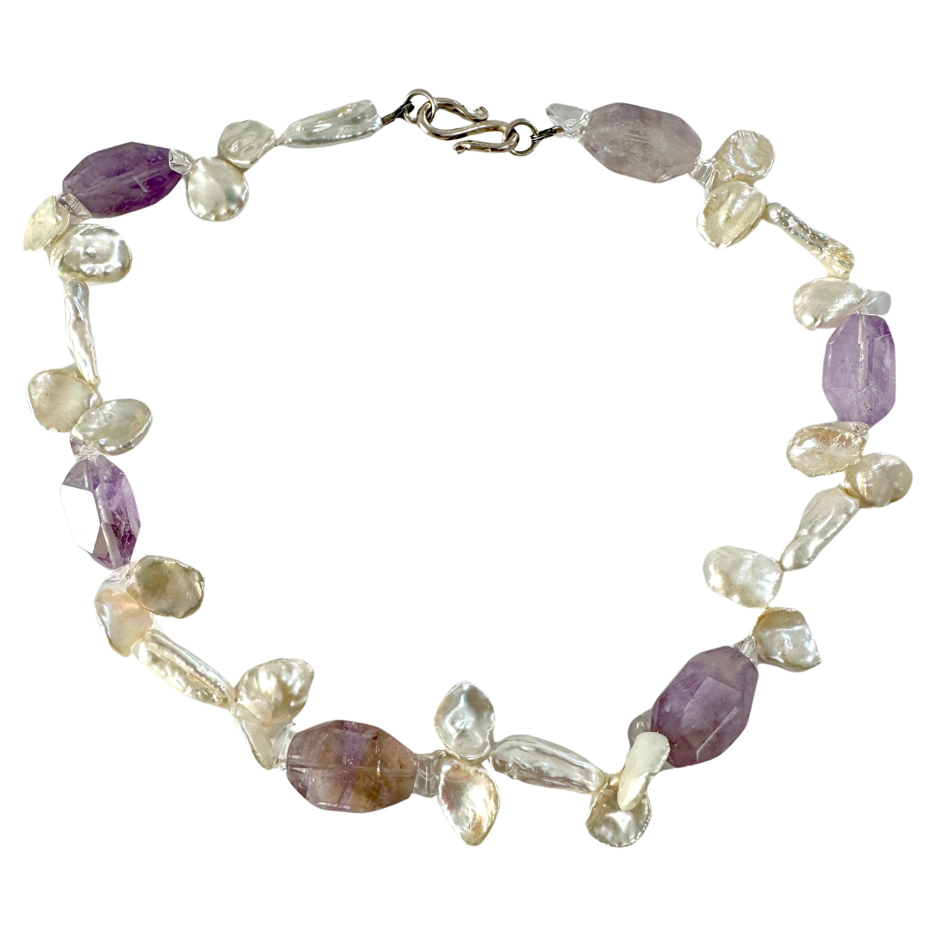 Collana di perle barocche d'acqua dolce Keshi con ametista
Perle keshi bianche naturali, uniche nel loro genere, fatte a mano e combinate con una grande pietra ametista e un cristallo.  Chiusura in argento 925 lunga circa 16