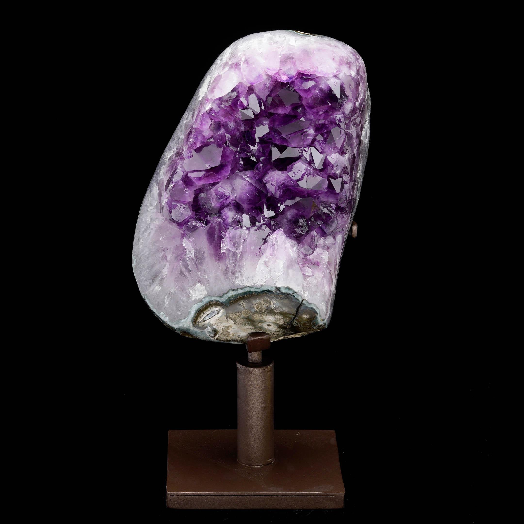 This striking Amethyst geode showcases stunning clusters of deep purple, sharply terminated crystals framed by bands of pale lavender and green agate. Expertly polished around the edges to highlight the natural beauty of the stone, the piece reveals