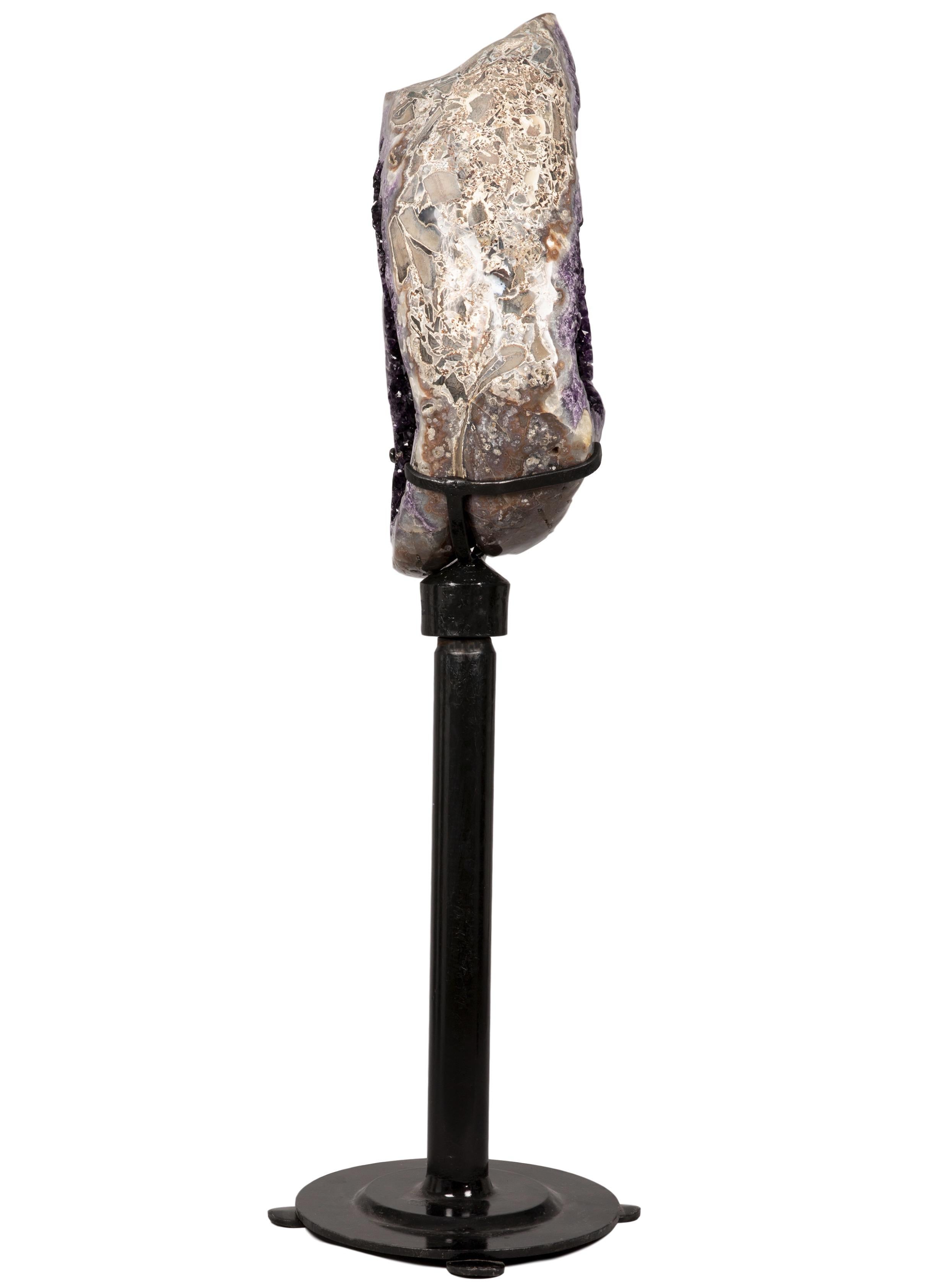 Stunning large geode slice on a custom metal rotating stand.

From its polished agate shell on the outside, to the rich purple amethyst crystals inside, this piece presents an exquisite combination of minerals on a sculptural journey. 

The