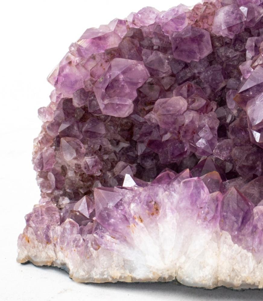Large amethyst geode specimen fragment, with a large and fine display of amethyst crystals with unfinished stone exterior. Measures: 13
