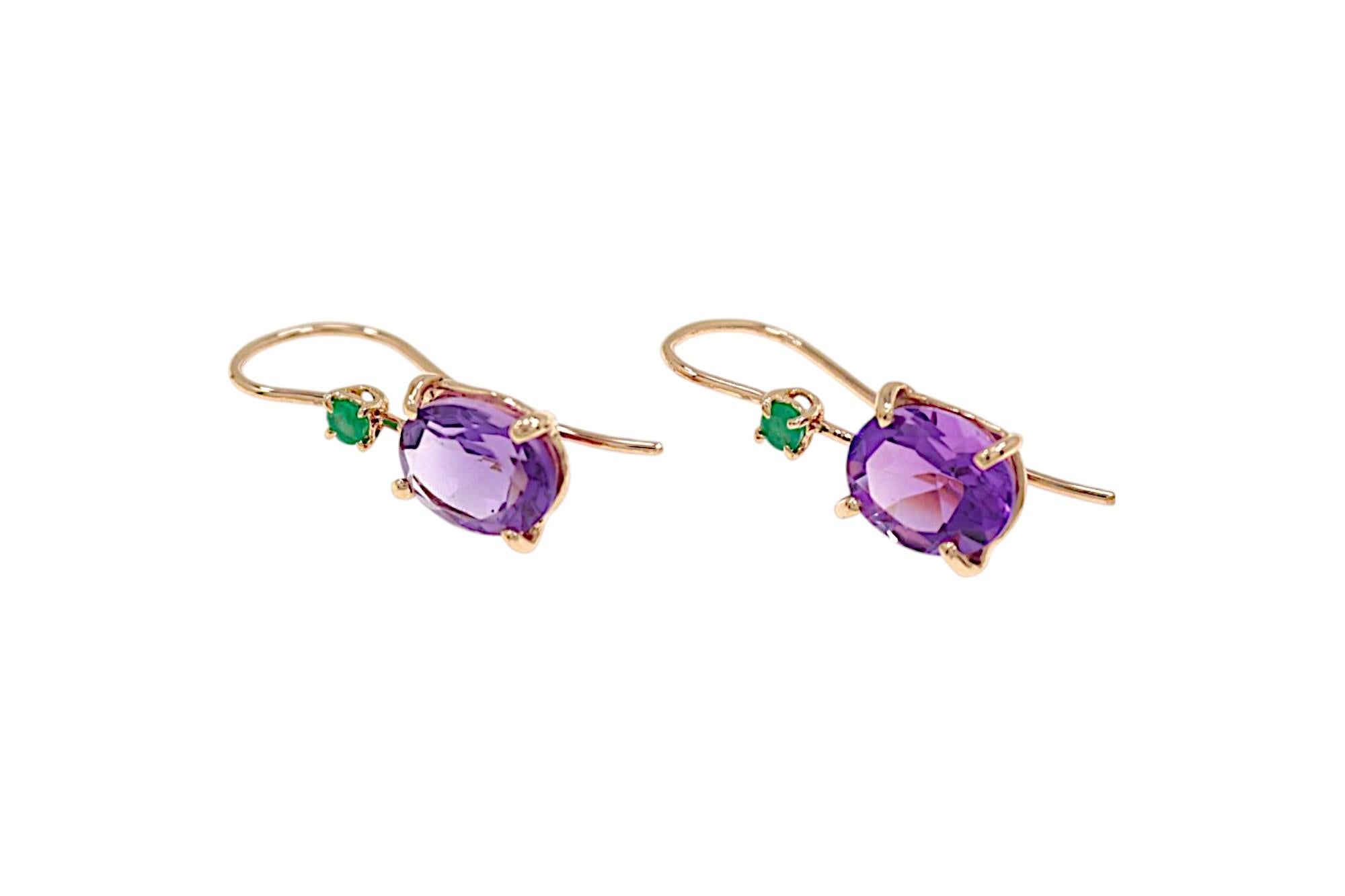 Elegante Ohrringe mit zwei natürlichen ovalen Amethysten und zwei natürlichen grünen Smaragden. Die Ohrringe haben ein offenes Design auf der Rückseite. Die beiden ovalen Amethyste im Brillantschliff sind jeweils 8x10 mm groß und haben ein