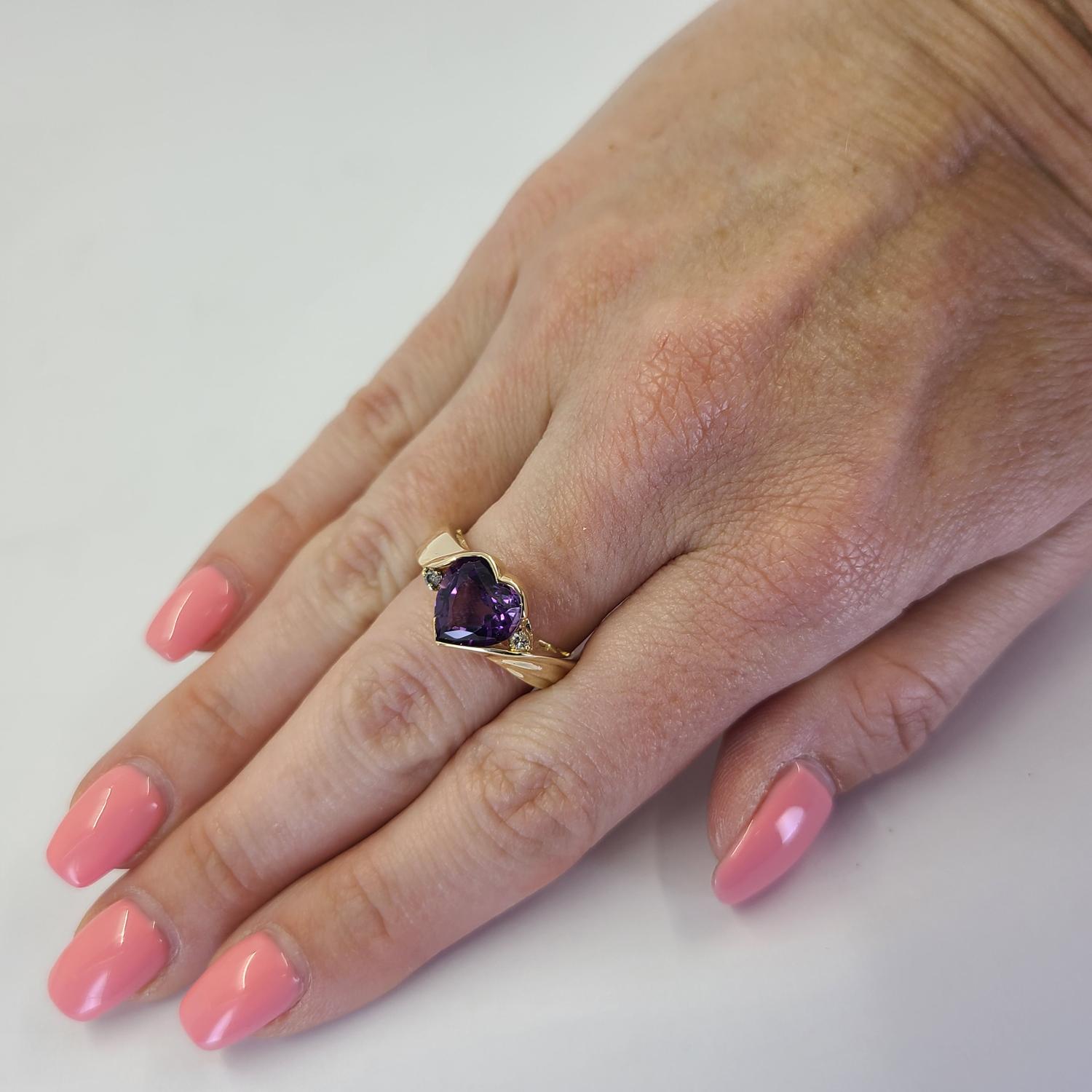 14 Karat Gelbgold Herz Ring mit einem Amethysten mit einem Gewicht von ca. 1,00 Karat, akzentuiert durch 2 runde Diamanten im Brillantschliff mit SI Reinheit und H Farbe von insgesamt 0,04 Karat. Fingergröße 7. Fertiges Gewicht ist 6,4 Gramm.