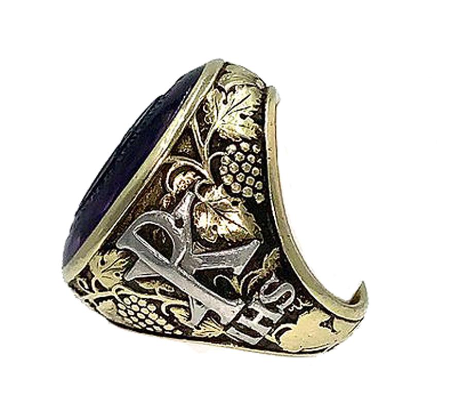 Large Amethyst Intaglio Bishop Ring! The oval amethyst gemstone, engraved with a symbolic seal, is mounted in a beautifully crafted 18k yellow gold setting. The amount of detail incorporated in the design of this ring is extraordinary. Intaglios