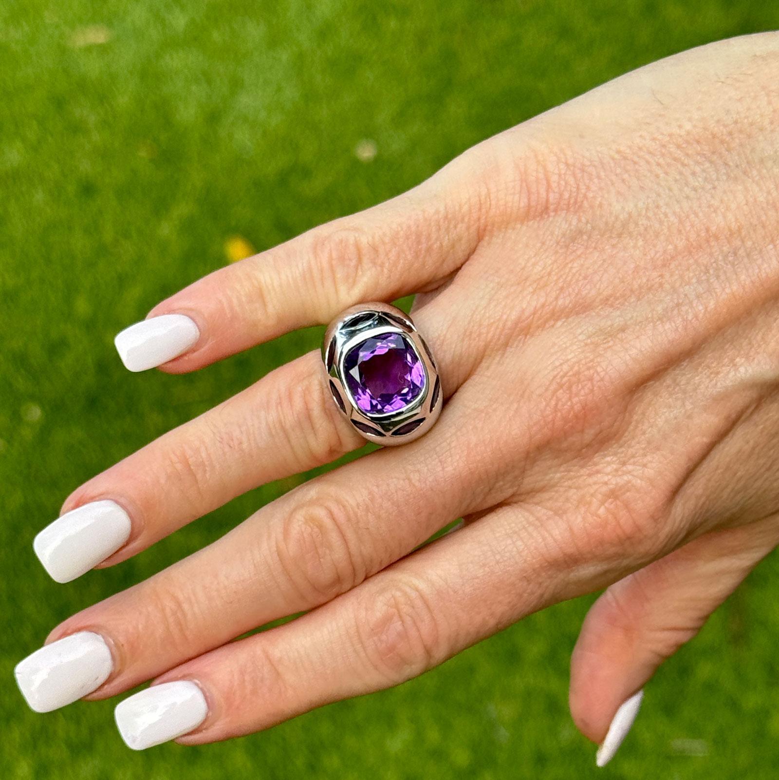 Dieser modische Ring aus 18 Karat Weißgold mit Amethysten und Iolithen besticht durch einen Amethyst im Kissenschliff in der Mitte, der mit seinem tiefvioletten Farbton besticht. Der Amethyst ist von schönen Iolith-Edelsteinen umgeben, die einen