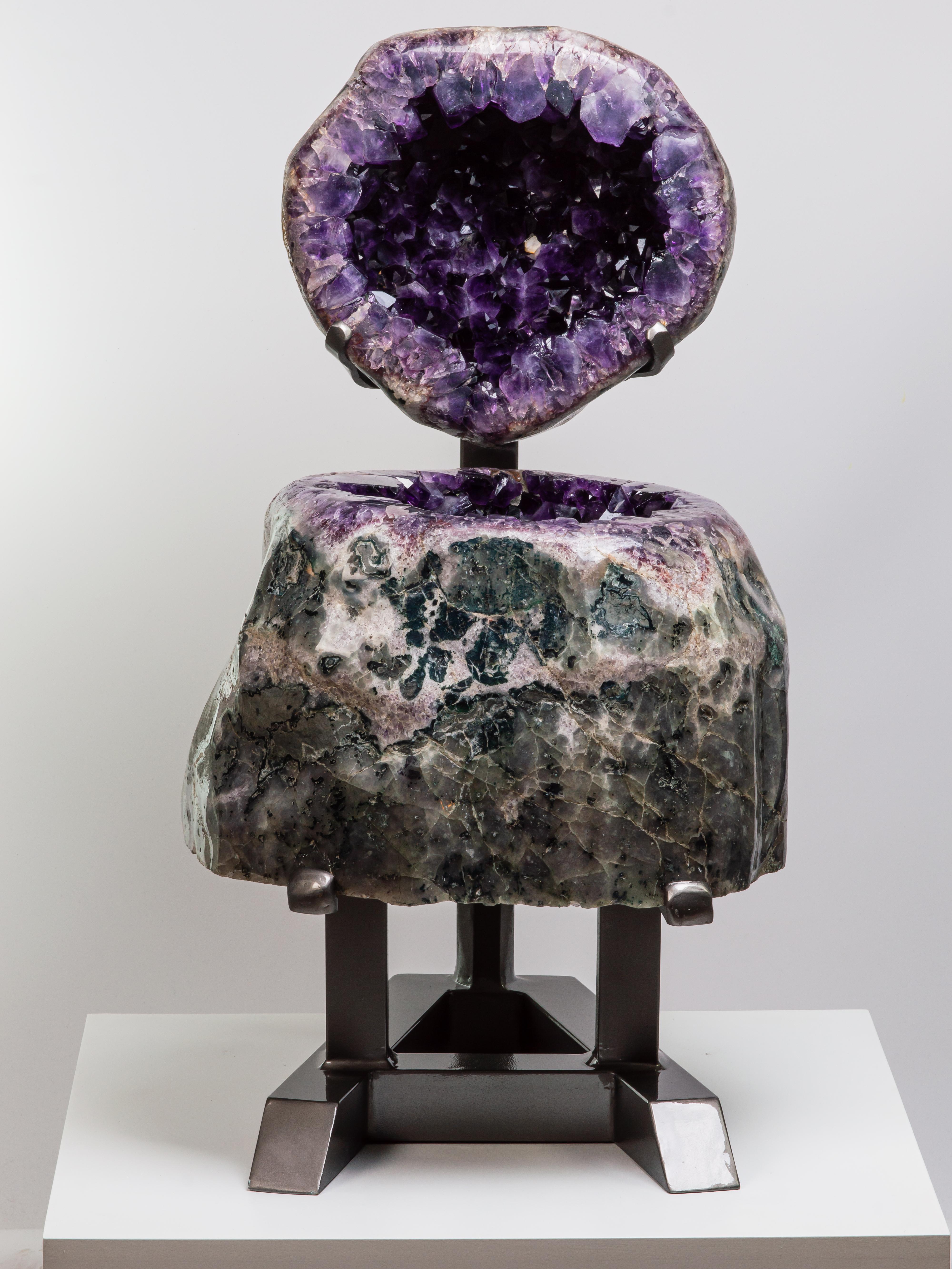In this alternative display, the stunning large geode with its agatised borders is
shown with the top presented vertically. The deep purple, high peaked crystals
are visible on the top and bottom sections, with a small calcite adorning the