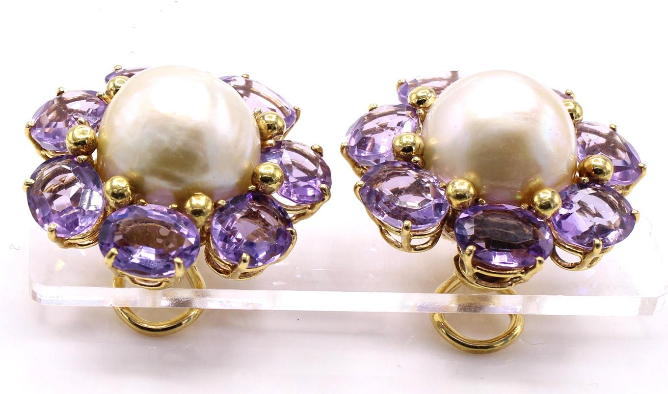 In a lovely floral design these 18 karat yellow gold ear clips are centrally set with 2 large mabe pearls and surrounded by perfectly matched pastel purple oval shaped amethysts. Secured by large omega clip backs 