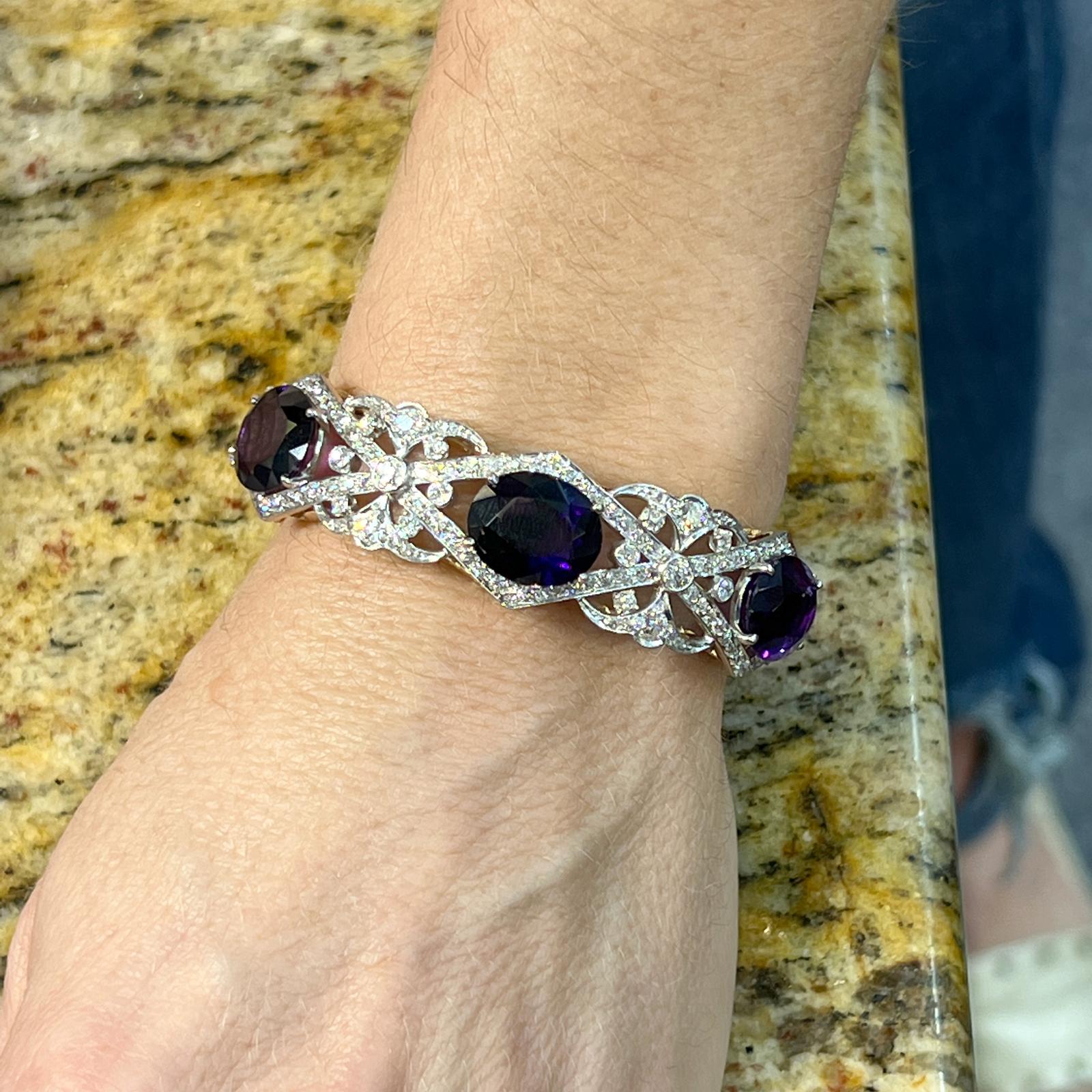 Beautifully preserved amethyst and diamond bangle fashioned in platinum and 14 karat yellow gold. The 3 oval amethyst gemstones weigh appproximately 18 CTW, and 26 Old European cut diamonds weigh approximately 3.80 CTW and are graded H-I color and