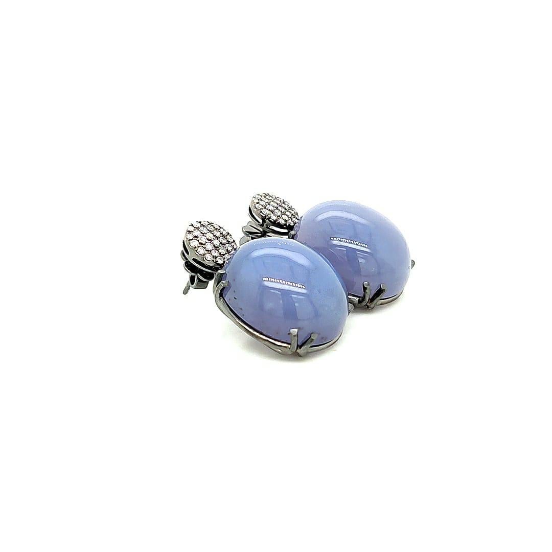 Blue Chalcedony Oval Cab with Diamonds Motif Earrings in 18K White Gold from 'Rock N Roll' Collection

Stone size: 20 x 17 x 9.5 mm

Gemstone Weights:  47.77 Carats

Diamond: G-H / VS, Approx Wt: 0.49 Carats