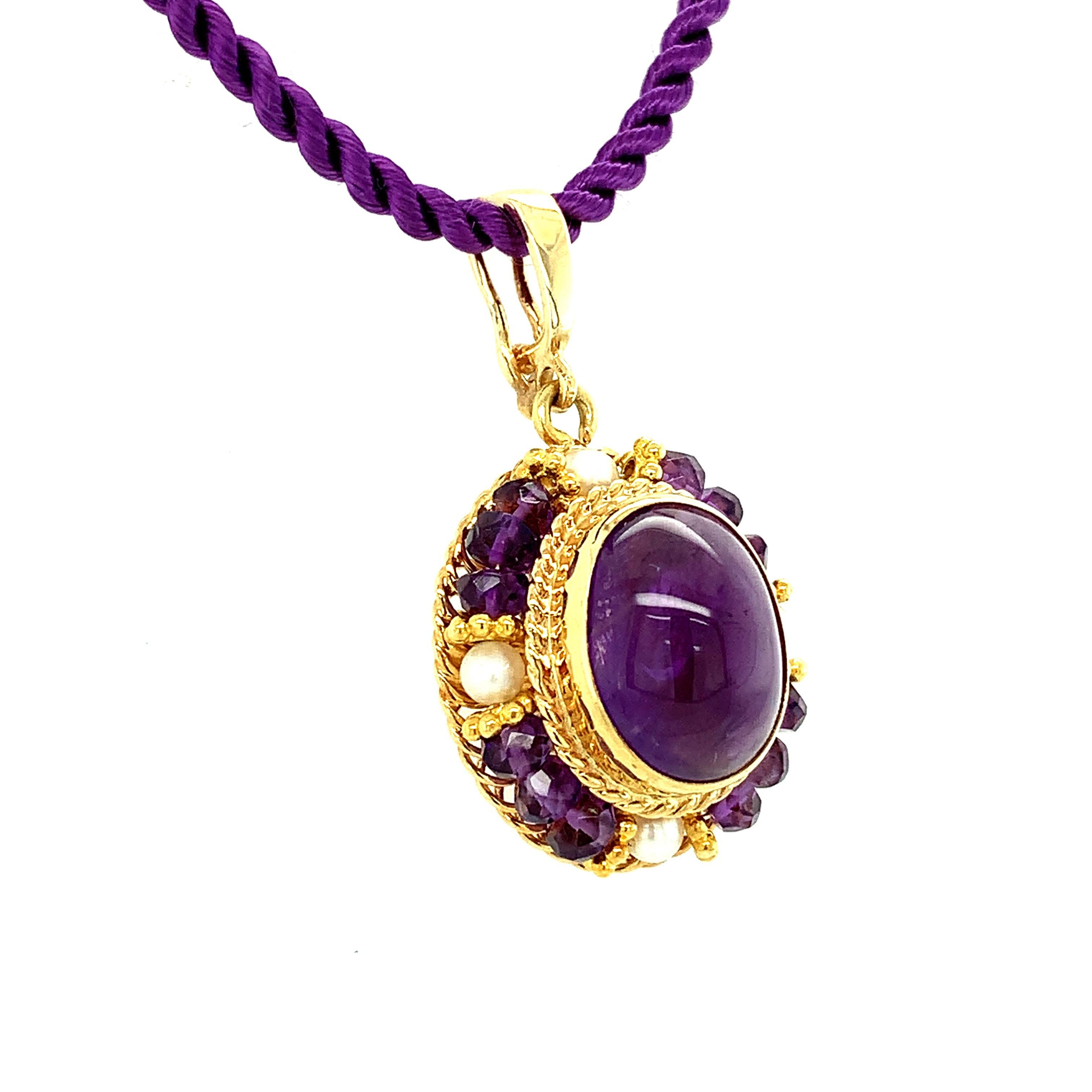 This elegant drop pendant features an oval amethyst cabochon with beautiful rich purple color, bezel set in a lovely handmade filigree setting. Amethyst beads and seed pearls are arranged in a halo frame around the center gem, accented with fine 18k