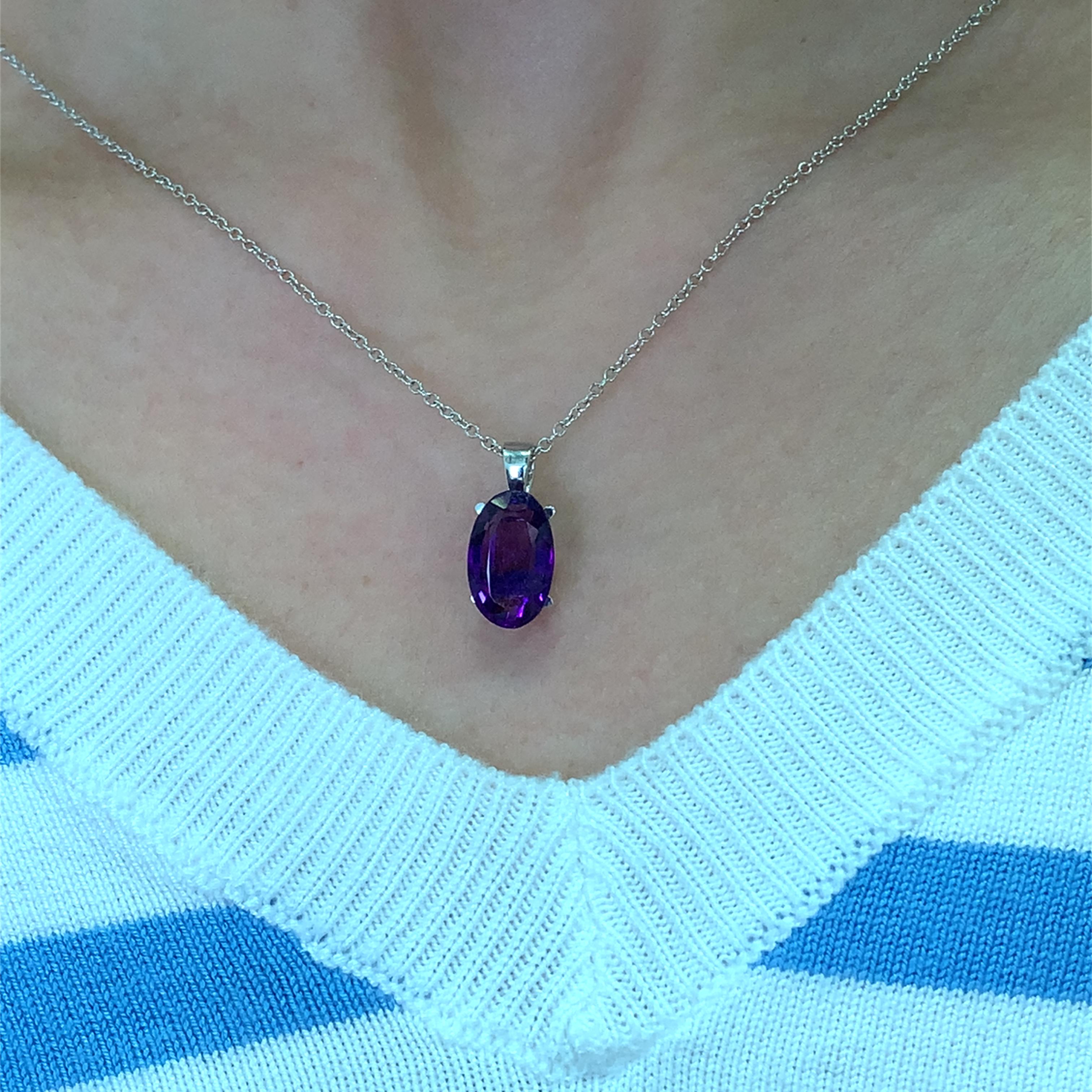 Questa splendida collana con ciondolo di ametista allungata da 3,40 carati presenta una gemma ovale dal taglio meraviglioso di circa 13/8 mm, che emana una ricca tonalità viola. Incastonato in un'elegante catena in oro bianco 18 carati, aggiunge un