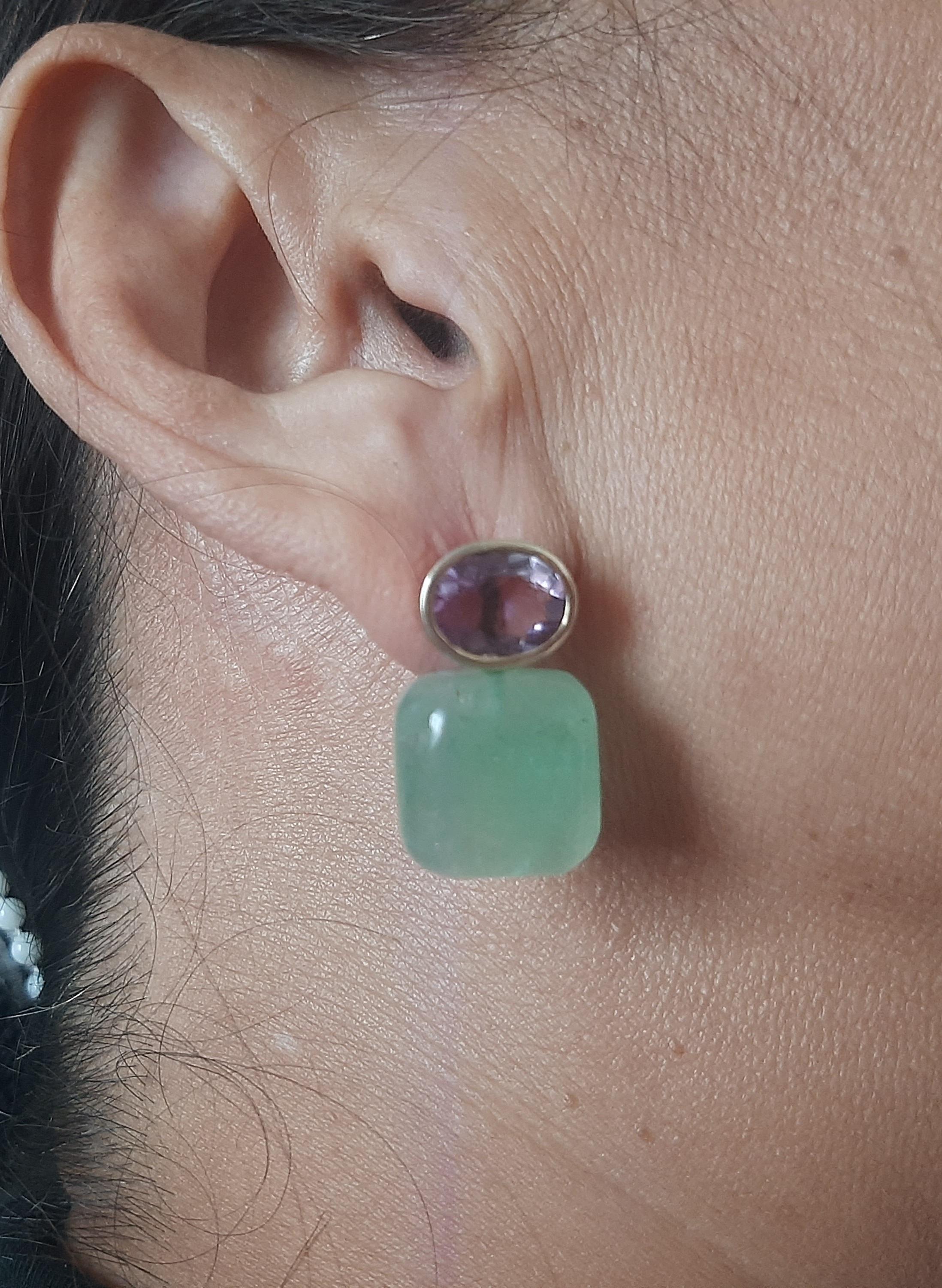 Questi semplici ma eleganti orecchini fatti a mano hanno 2 ametiste ovali sfaccettate di 8 x 10 mm incastonate in un castone in oro giallo 14 Kt alla cui sommità sono sospese 2 avventurine verdi a forma di cuscino di 15 x 15 mm.

Nel 1978 il nostro