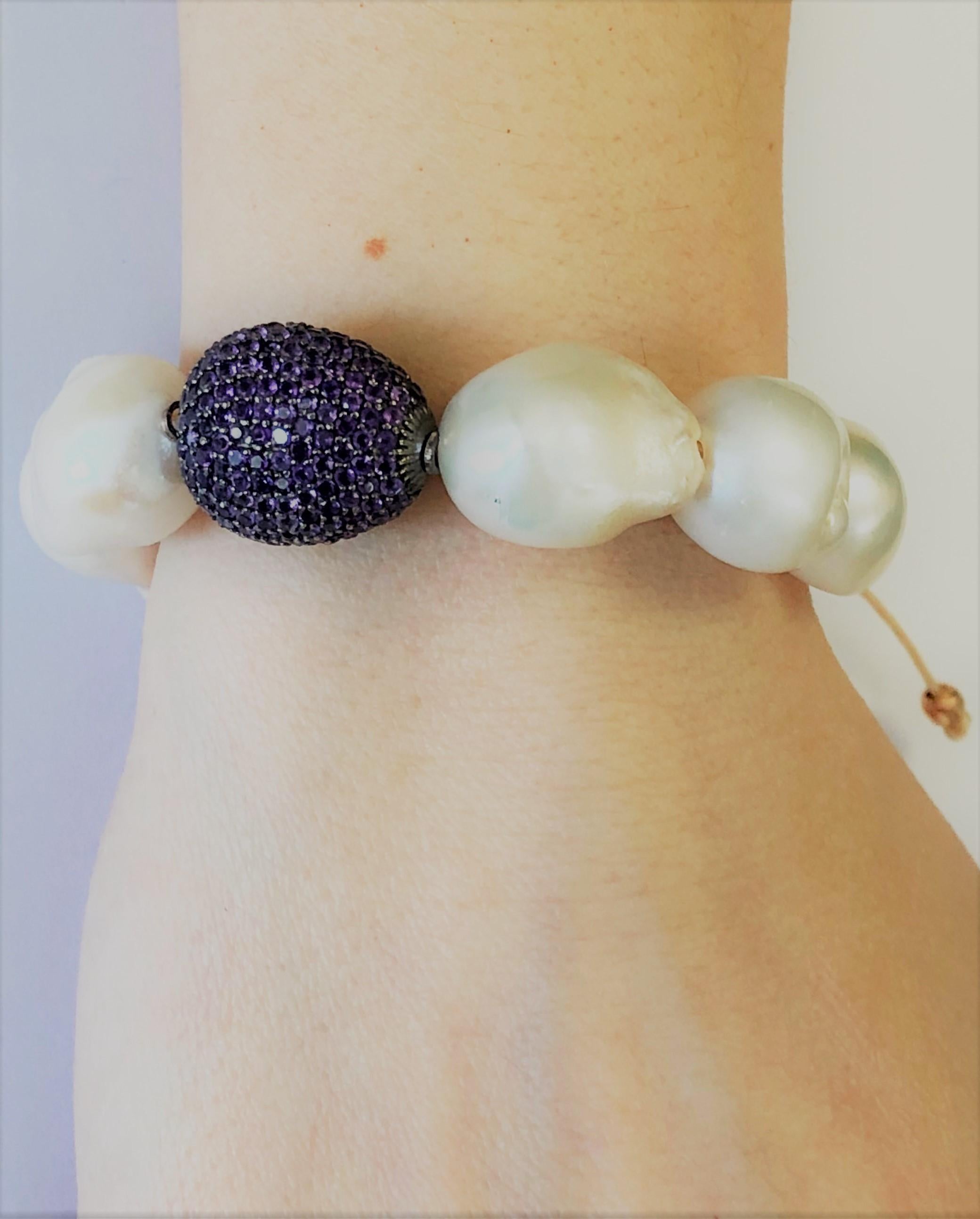 Nice bracelet made up of  amethyst pave on silver setting, baroque white pearls and macrame clasp. 
Amethyst pave ct. 6,30
Baroque white pearls
macrame clasp system
Total diameter cm 6,8 - it fits well for a medium wrist ( about 15 cm) 