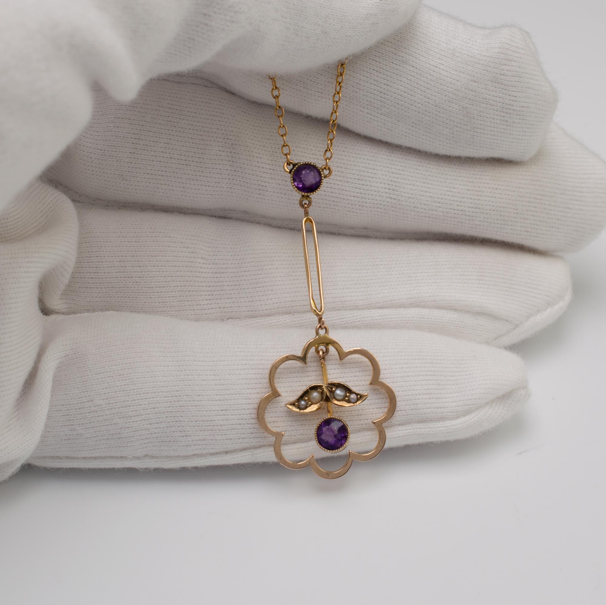 This beautiful vintage amethyst and pearl pendant features a hanging amethyst with graduated pearls set in leaf shapes to form a flower or fruit within the scallop shape gold frame with further amethyst to the top of the pendant with a split