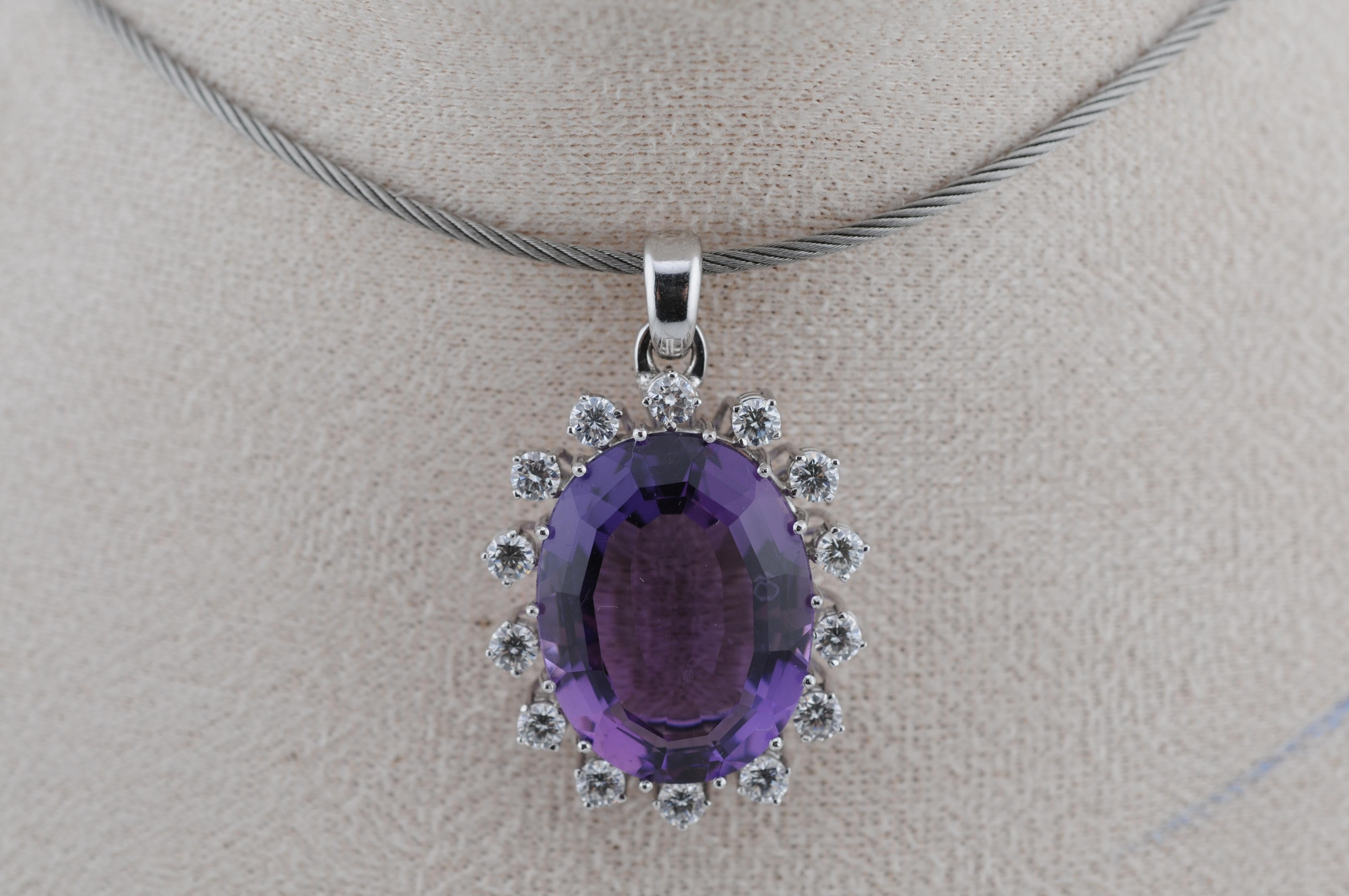 Grande pendente di ametista di circa 40 carati, incastonato in oro bianco 18 carati e impreziosito da diamanti a taglio brillante.
I diamanti sono circa 0,10 carati ciascuno, per un totale di circa 1,4 carati.
Peso totale del pezzo: 12.95 g.

Un