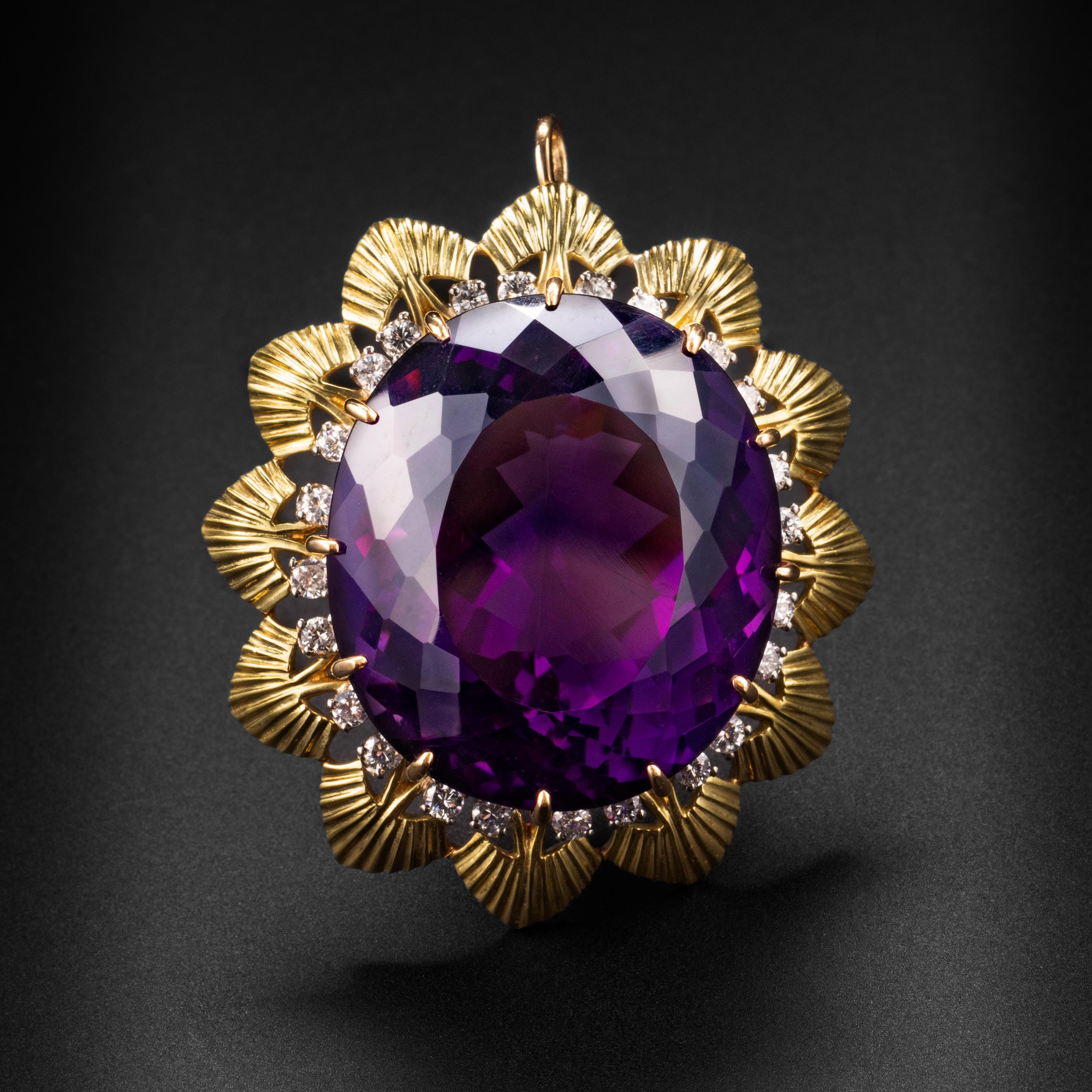 This singularly spectacular pendant -which can also be worn as a brooch- features an absolutely massive 27 x 24mm natural rich purple amethyst weighing over 55 carats. The prong-set gem is embellished with 27 bright and sparkling full-cut diamonds