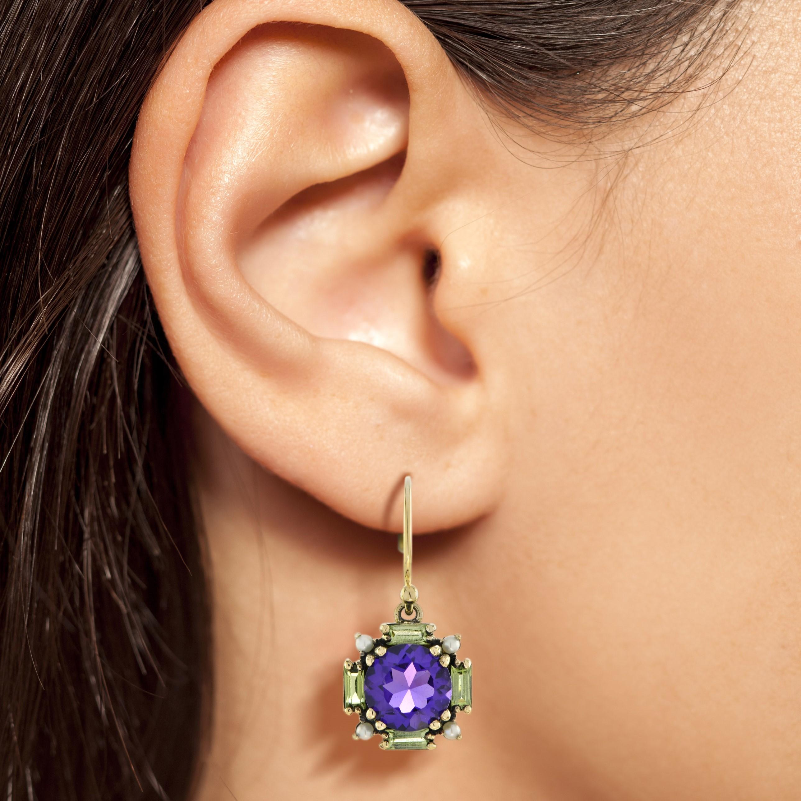 A stunning combination of gemstones, creating a captivating design. The vibrant amethyst and peridot are elegantly set in an Art Deco arrangement, with each gemstone reflecting light and adding a pop of color. A lustrous pearl at the corners