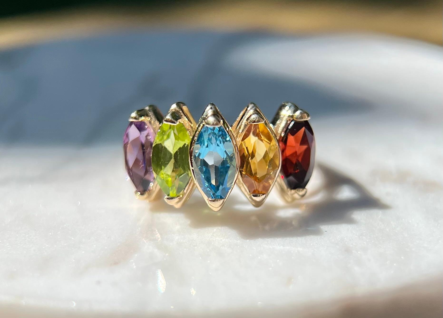 One 14 karat yellow gold five stone ring set with one 7x4mm marquise-cut amethyst, one 7x4 marquise-cut peridot, one 7x4mm marquise-cut blue topaz, one 7x4 citrine, and one 7x4mm garnet stone.  The ring is a finger size 6.5 and is resizable.  