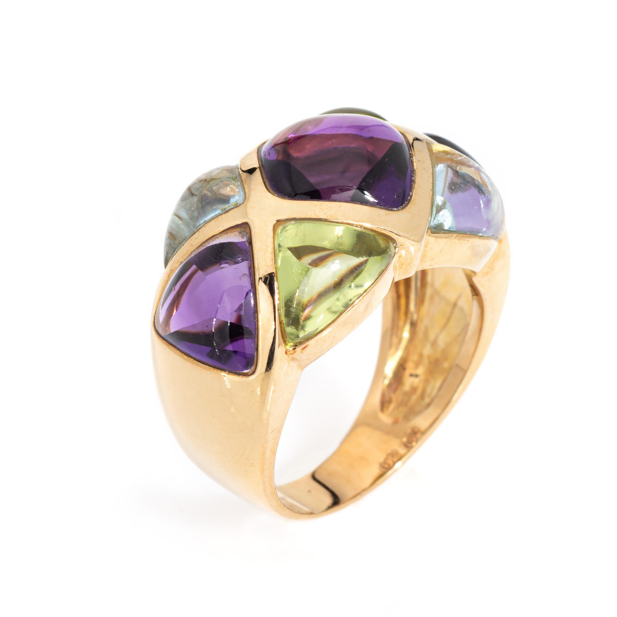 Stylish estate amethyst, peridot and blue topaz band crafted in 18 karat yellow gold. 

Cabochon cut amethyst measures 10mm x 9mm (center) and 7mm (sides). Peridot and blue topaz measures 7mm x 5mm. The semi precious gemstones are in good condition