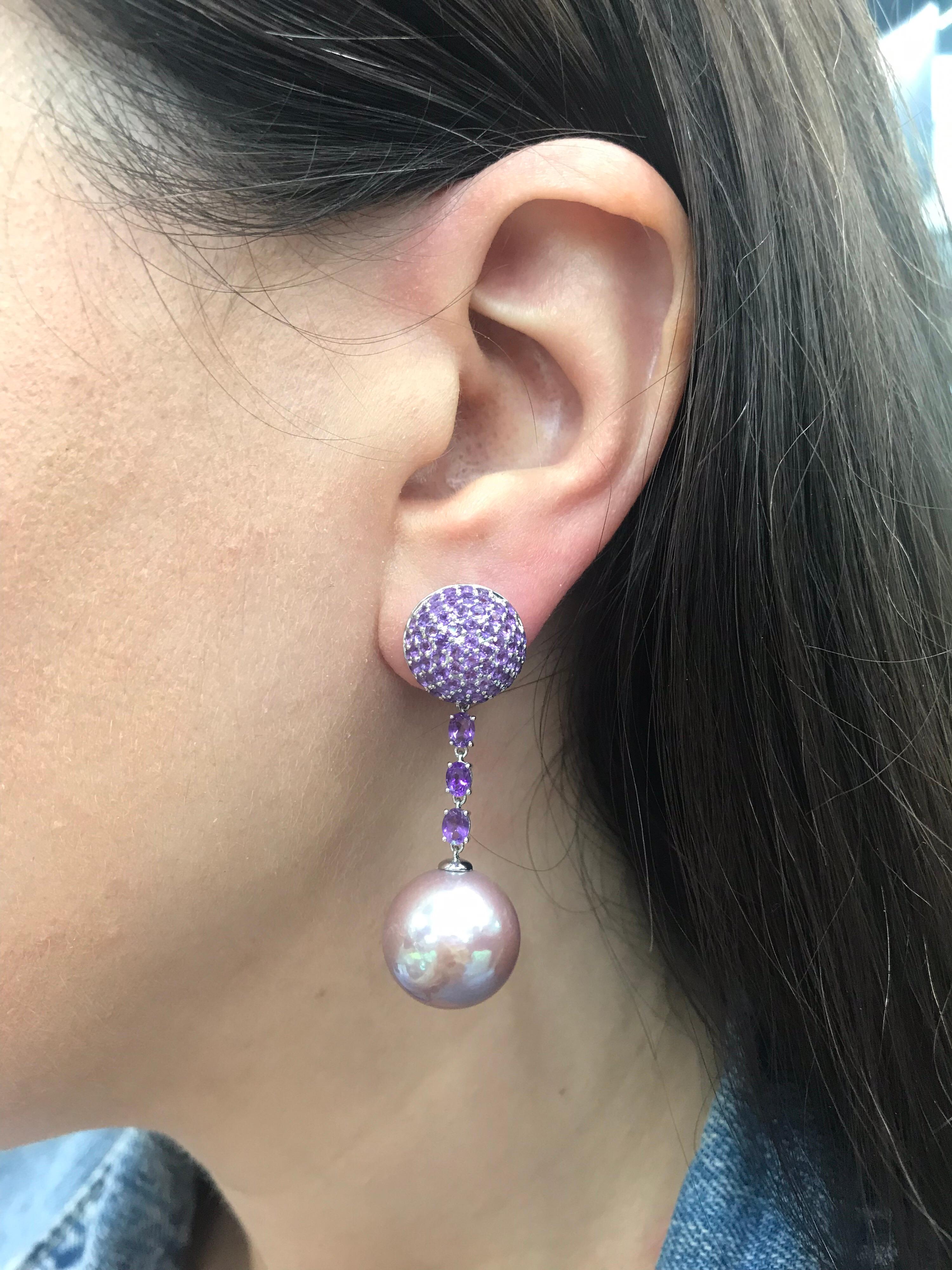 18K White gold drop earrings featuring two Pink Freshwater Pearls measuring 15-16 mm flanked with 154 Amethyst weighing 3.22 carats. 
