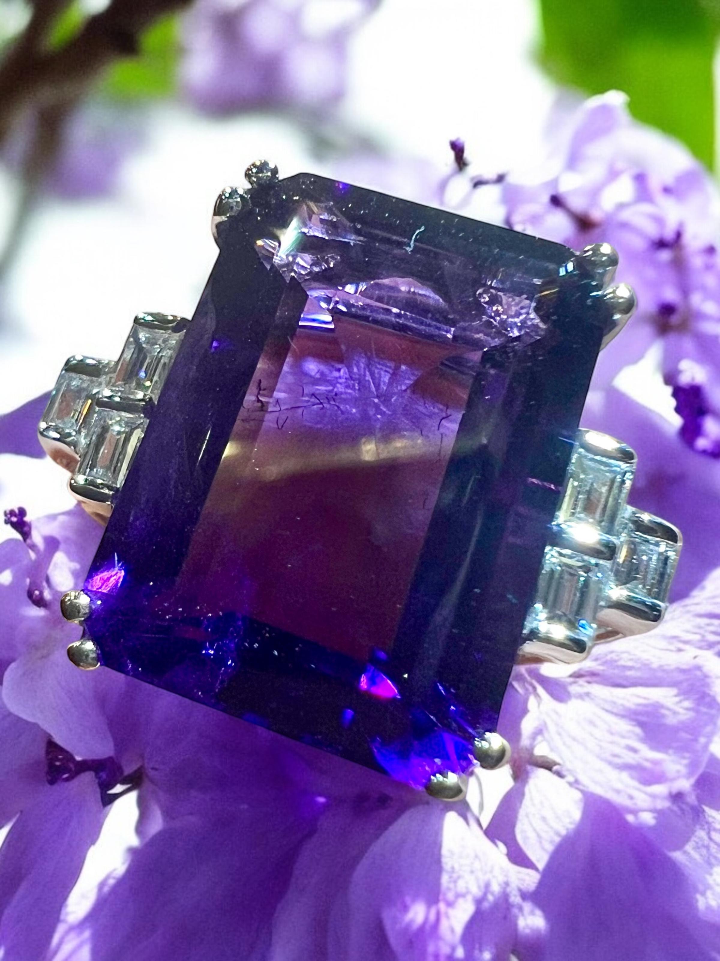 Magnificent ring set in its center with an amethyst of a very bright,
intense and very deep purple, on the entire flat surface of the stone,
of rectangular faceted size for approximately 17 carat in total surrounded by 6 calibrated diamonds for