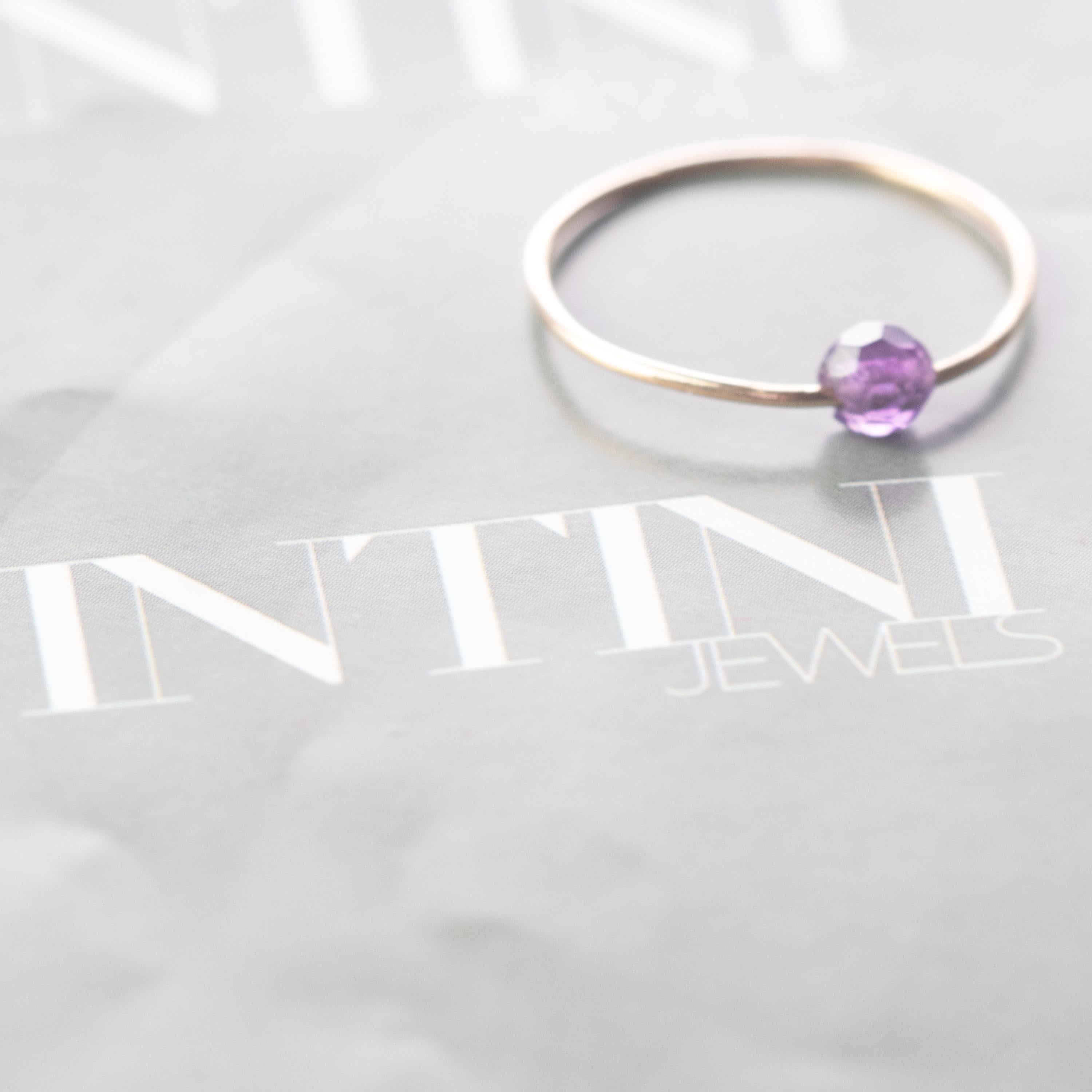 Anello a fascia Intini Jewels Purple Planet. Anello dal design contemporaneo in oro giallo 9 carati con una preziosa ametista rotonda. Design e colore mescolati in un unico gioiello. Deliziati con un design forte e minimalista, per un look chic e