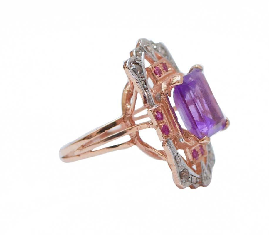 Anello Retrò in oro rosa 9 kt e struttura in argento montata con un'ametista centrale circondata da rubini e, esternamente, da diamanti.
Questo anello è stato realizzato totalmente a mano da maestri orafi italiani ed è in perfette