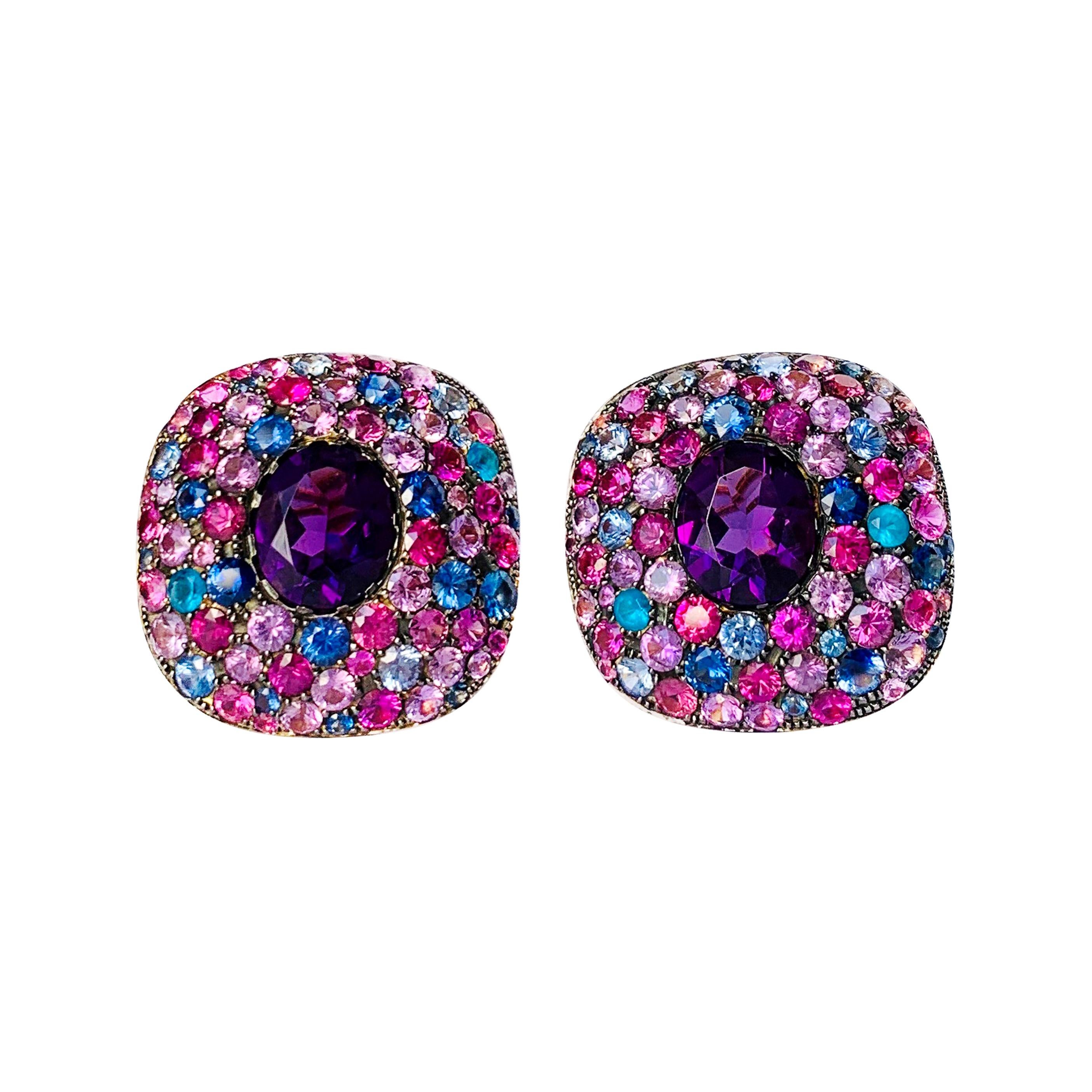 A Rosior by Manuel Rosas Contemporary Earclips set in 19.2k Yellow Gold with:
- 2 Oval Cut Amethysts with 8,17 ct, 
- 4 Apatites with 0,48 ct, 
- 64 Pink Sapphires with 9,96 ct, 
- 40 Blue Sapphires with 5,22 ct
- 41 Purple Sapphires with 5,64