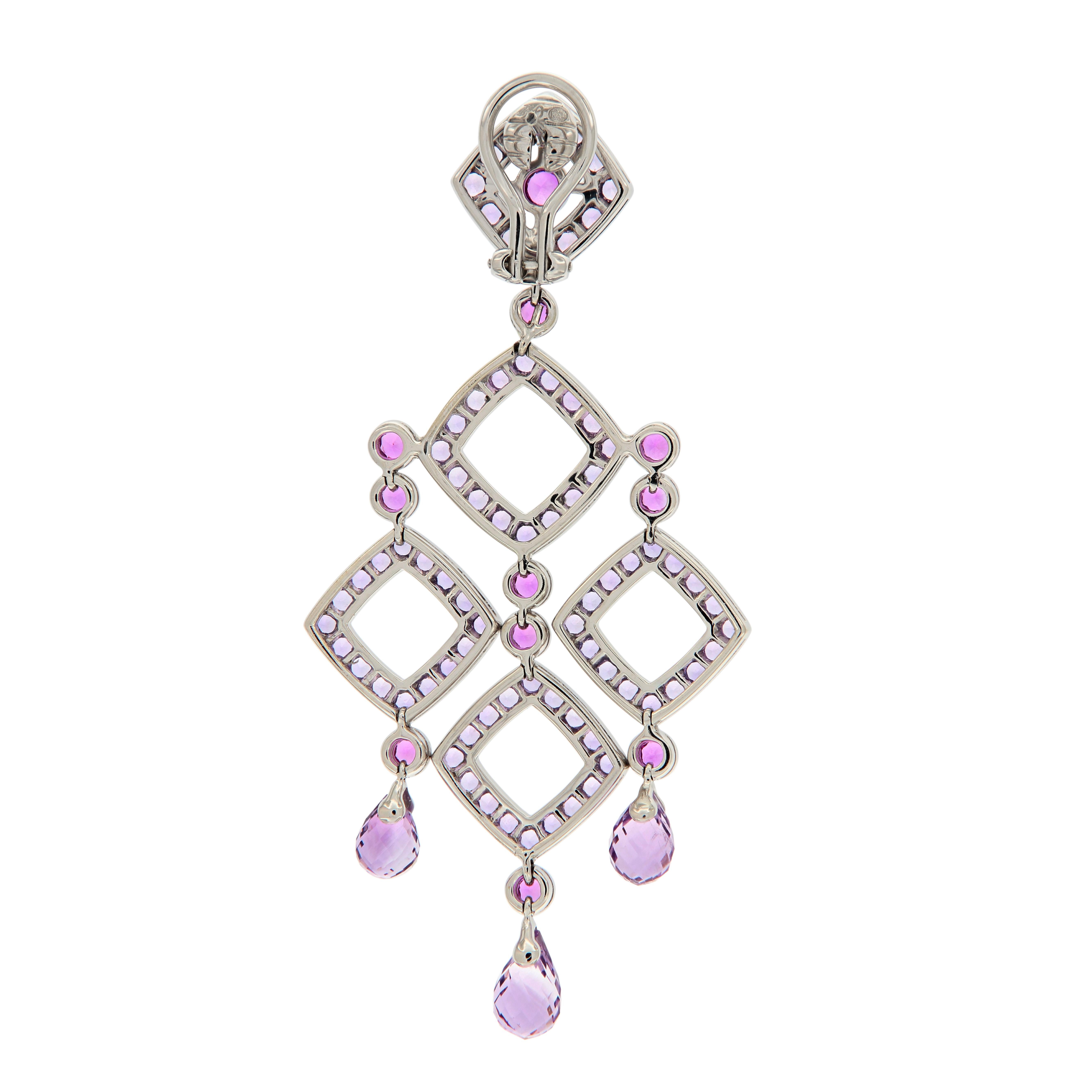 These statement chandelier earrings feature beautiful shades of violet to vibrant pink. Amethyst briolettes suspend from openwork geometric shapes connected by bezel set pink & violet sapphires . 1.22 inches wide by 2.5 inches long

Violet Sapphire