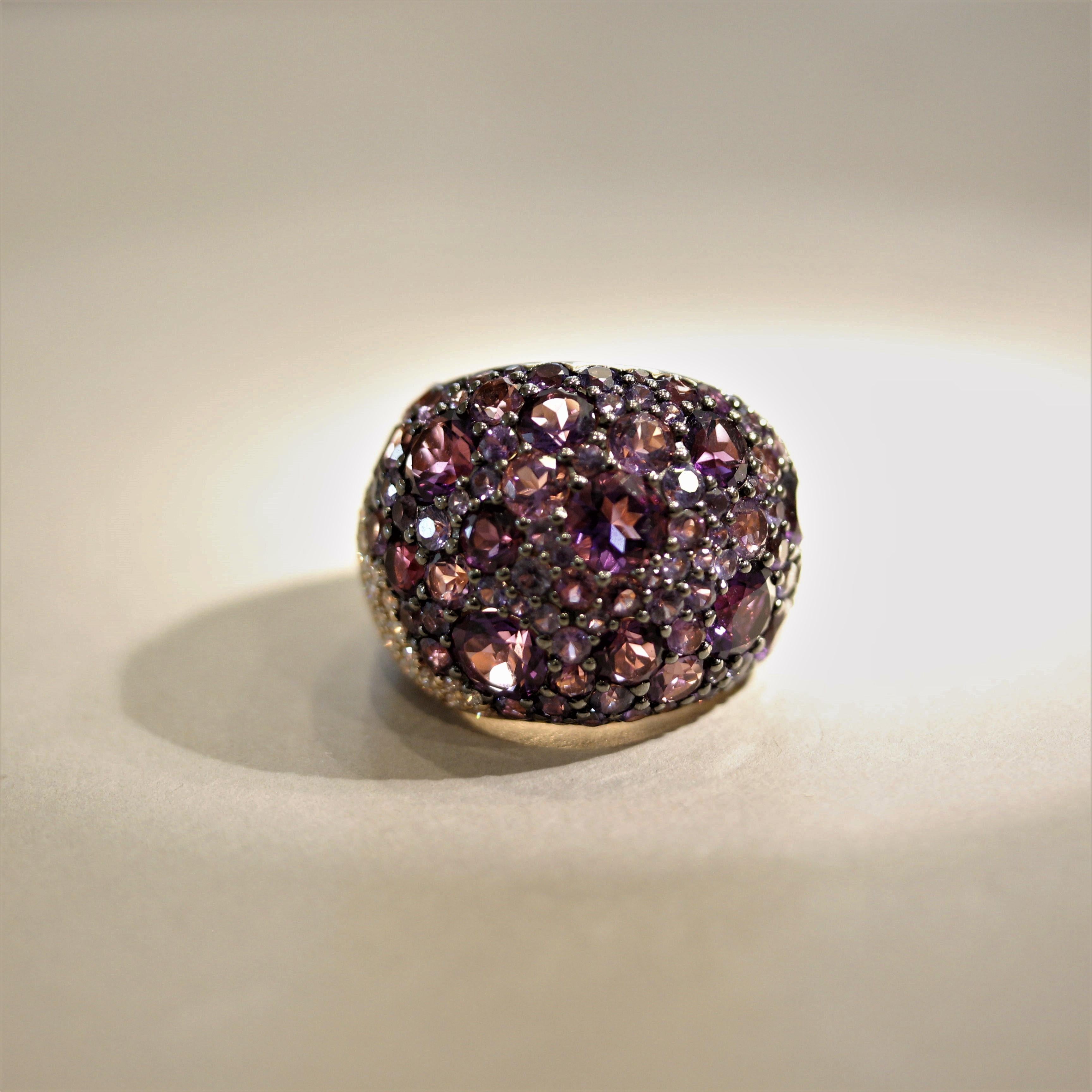 Simply a stunning and fashionable cocktail ring! It features 7.99 carats of round-shaped bright purple amethyst set across the ring. Adding to that are 2.40 carats of sapphires in various shades of purple which are pave-set between the larger