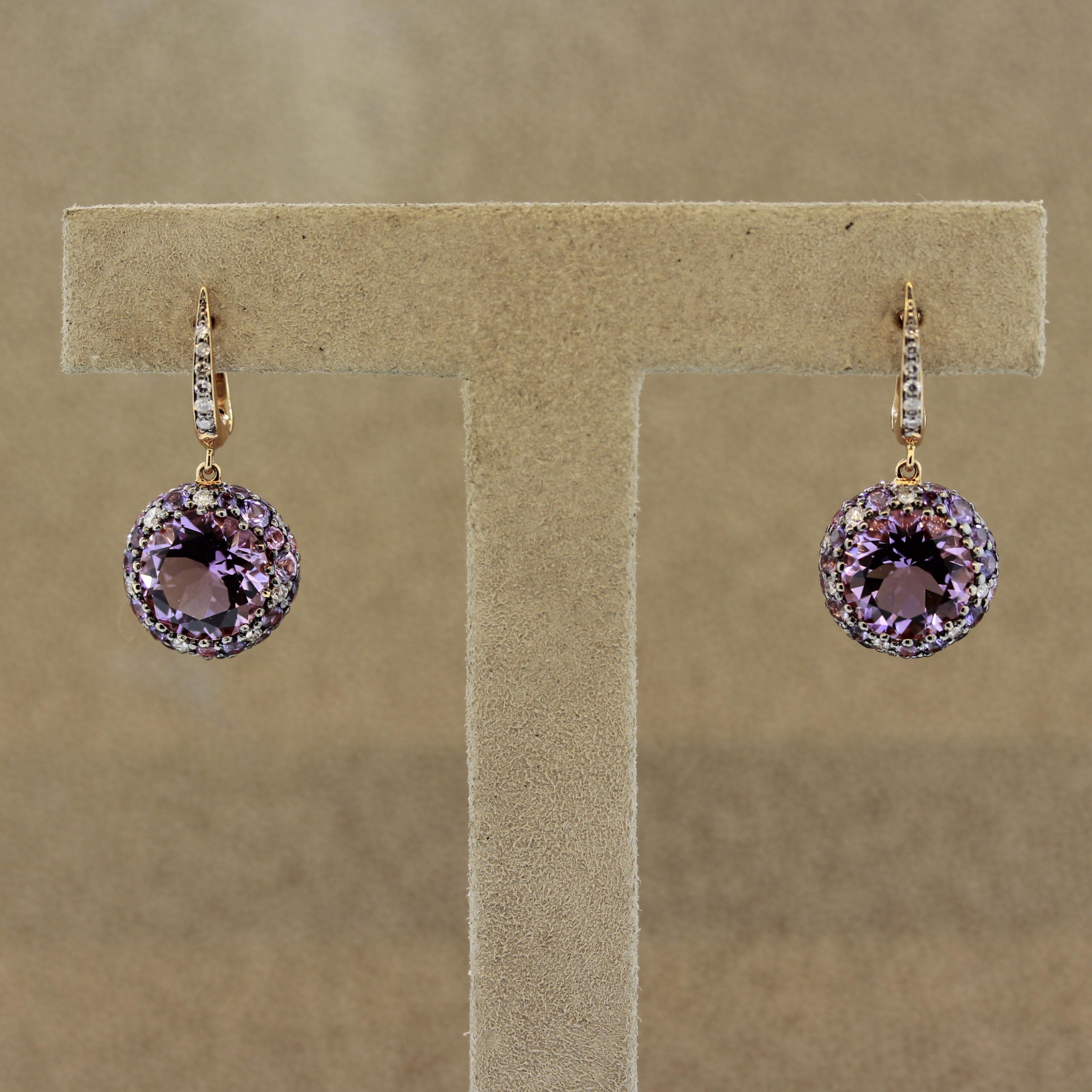 A stylish and chic pair of drop earrings. They feature a total of 2.46 carats of amethyst which are the two large center round stones. Adding to that are 2.70 carats of fancy pink and purple sapphire set around the sides along with 0.56 carats of