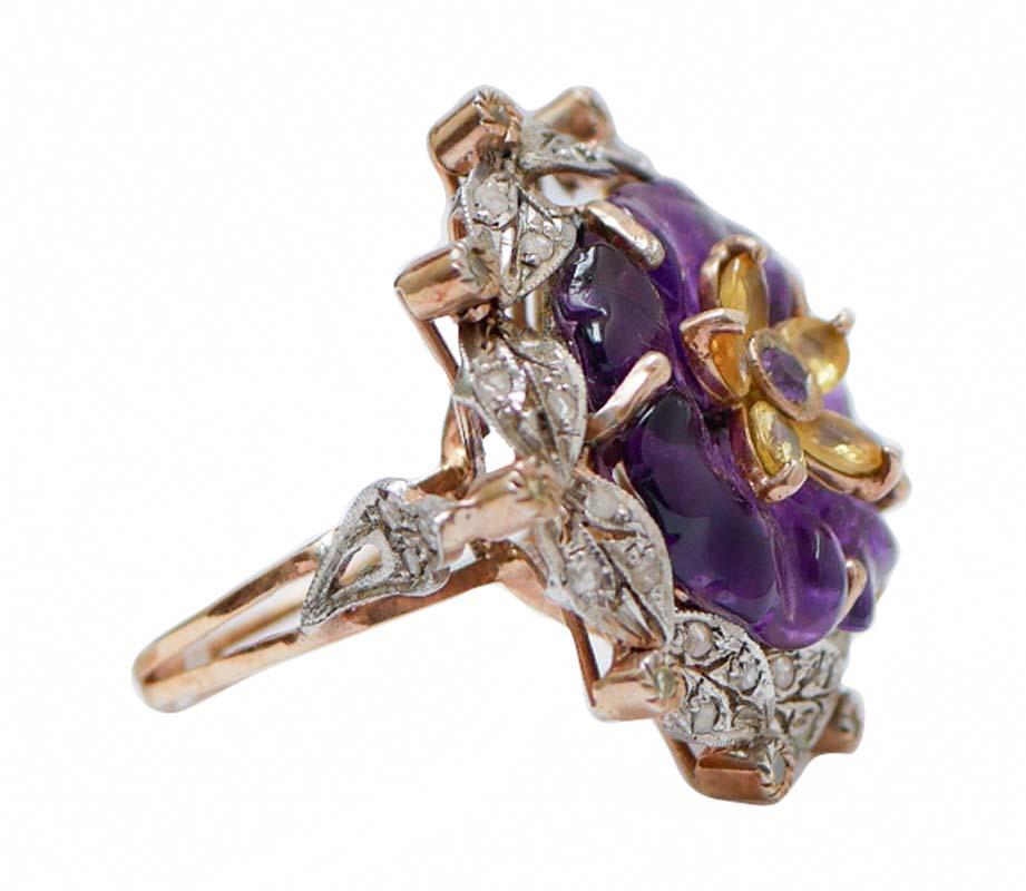 Ring Retrò aus 9 kt Roségold und Silberstruktur mit einer Blume aus hydrothermalem Amethyst in der Mitte und einer Blume aus Saphiren mit einem Amethyst in der Mitte. Rundherum ein Rahmen aus Diamanten.
Dieser Ring wurde vollständig von