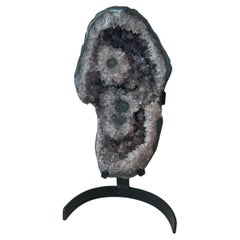 Escultura de amatista con ojos de estalactita sobre soporte