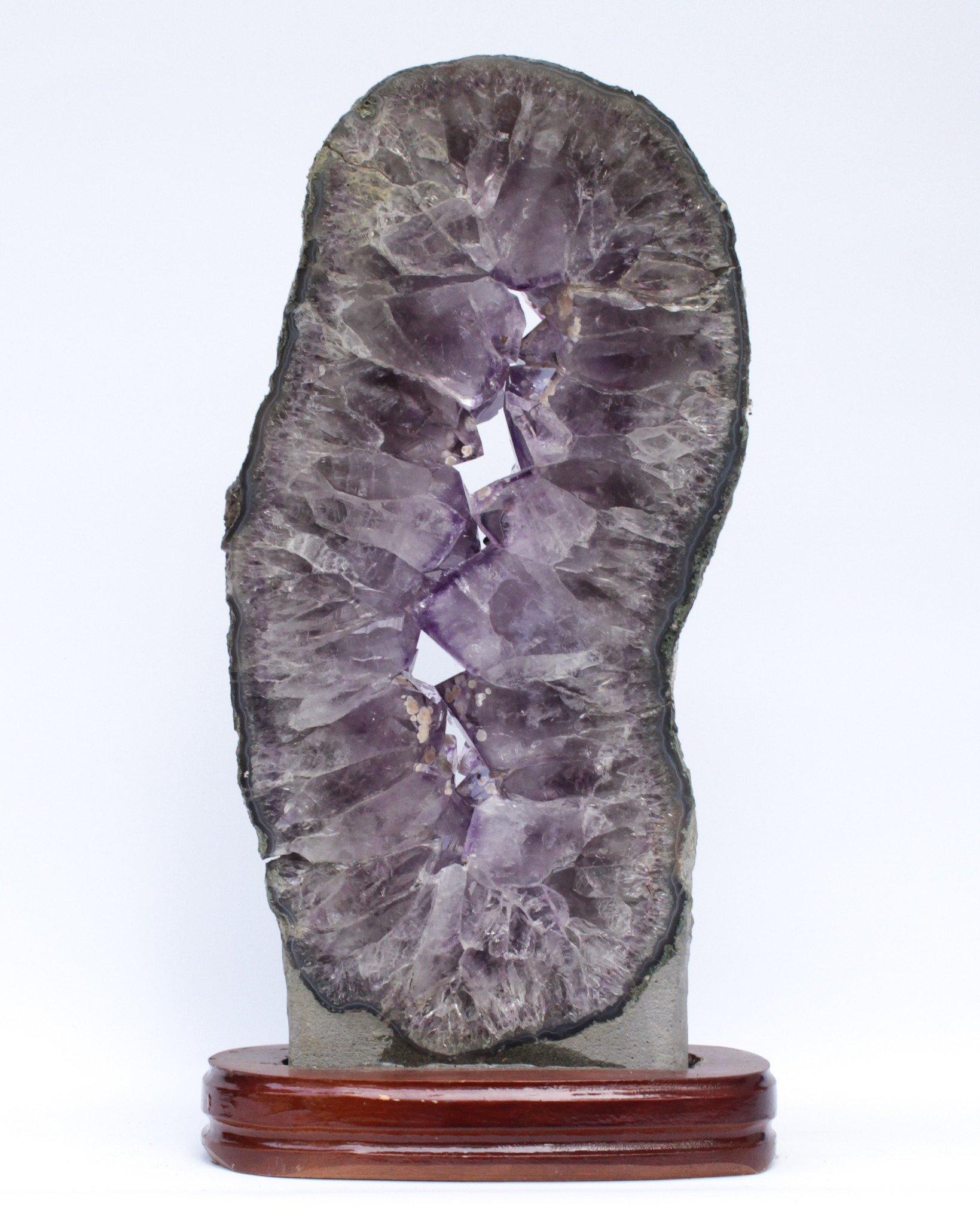 Brazilian Amethyst Slice with Calcite Deposits and a Baroque Pearl on a Polished Wood Base For Sale