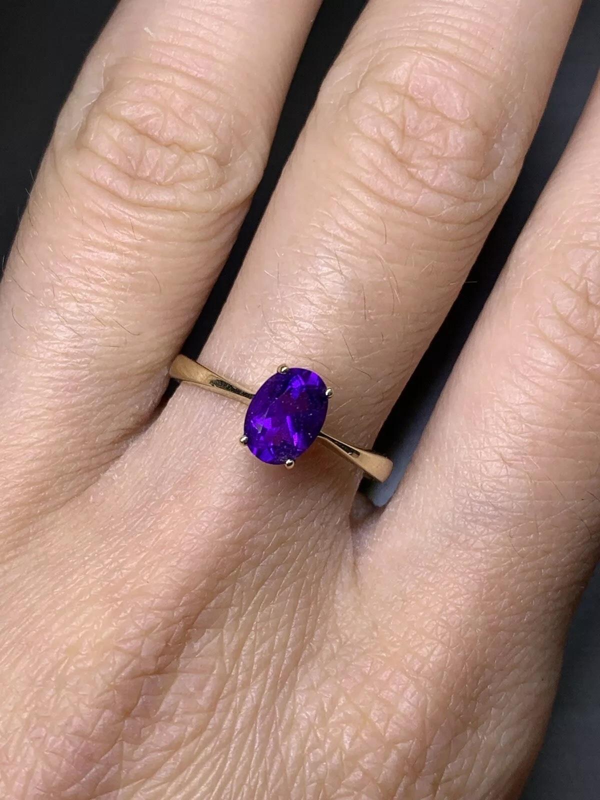 This beautiful ring features a stunning oval-shaped amethyst as the main stone, which has a natural creation and excellent cut grade. The amethyst is set in a classic solitaire setting on a 9ct yellow gold band with a width of 2mm. The ring is