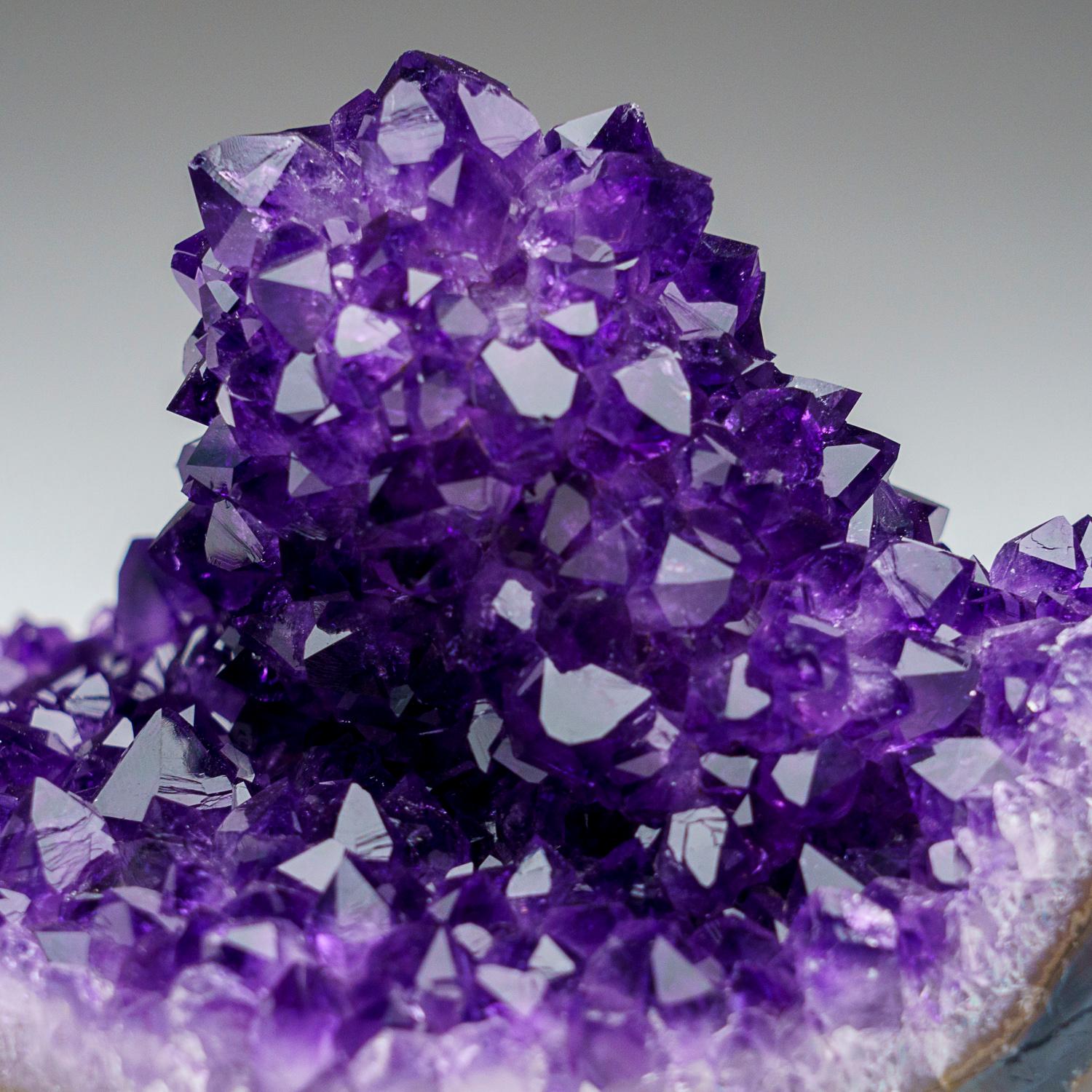 This specimen is a world-class, museum-quality Showy cluster of lustrous purple amethyst quartz crystals from the famous mining district near the Brazilian border, the famous regions of Artigas, Uruguay. The crystals, showcasing a rich purple color,