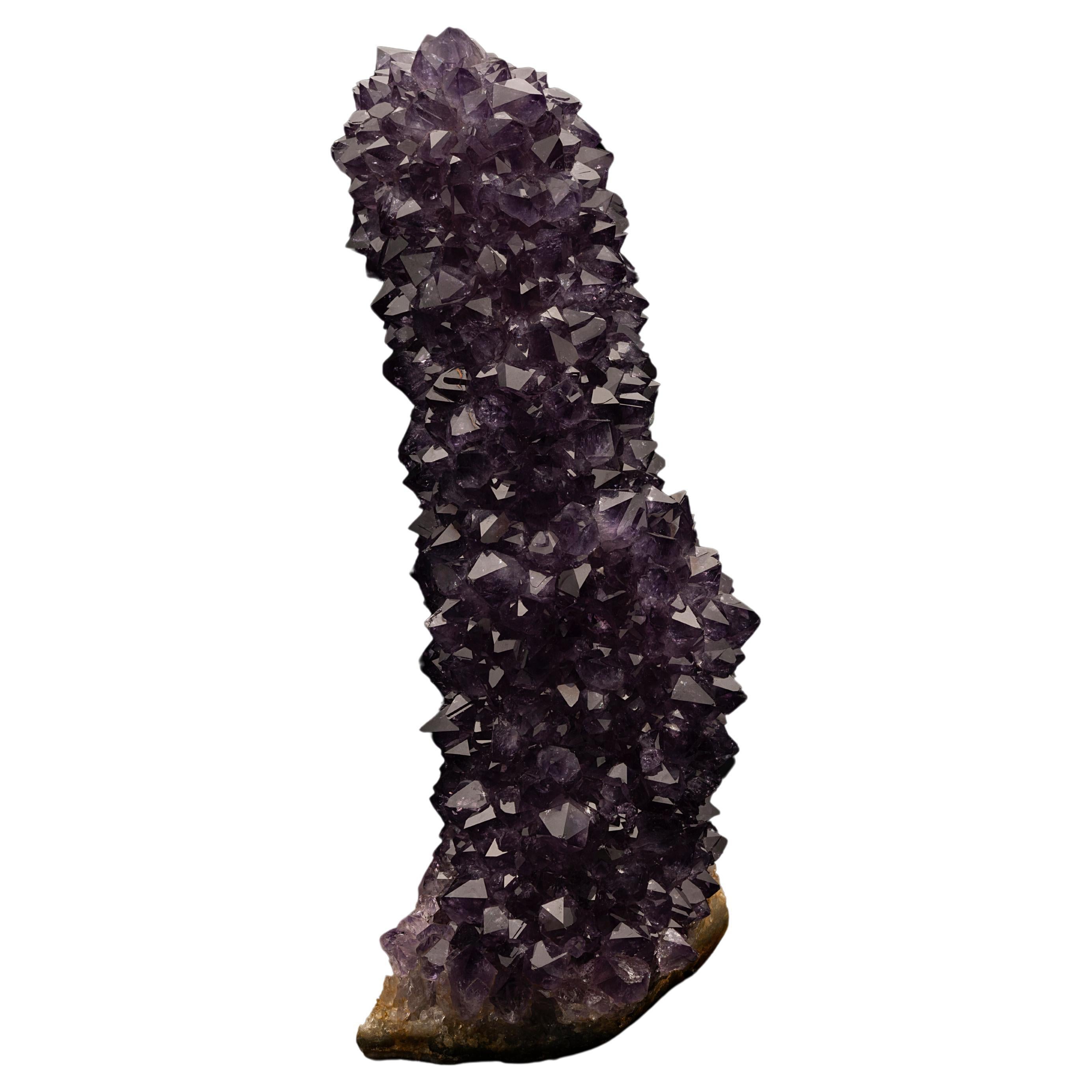 This glimmering Uruguayan amethyst stalactite features purple-drenched, perfectly terminated amethyst crystals. These amethyst stalactites are only known to grow inside geodes found in Uruguay. This specimen is uniquely perfect, with no dings and no