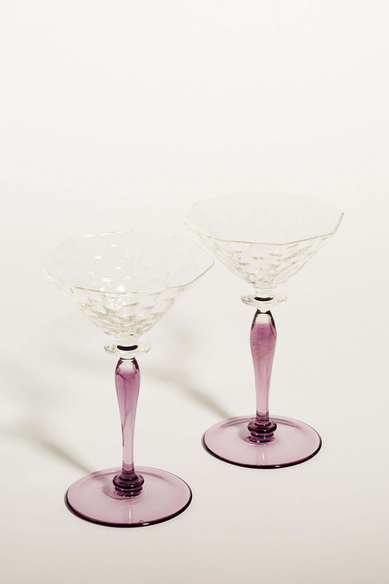 Elegant set of two wine glasses with rippled clear glass bowls and amethyst baluster style stems.

