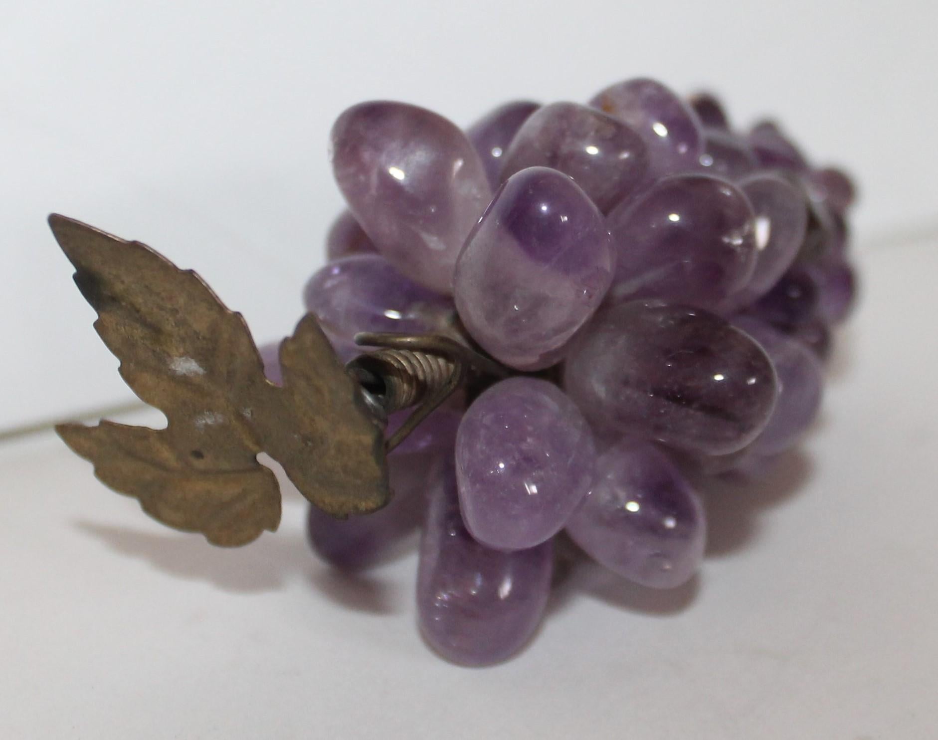 These Italian amethyst mini stone grapes that are wired together and little mini leafs attached. The condition is very good.
